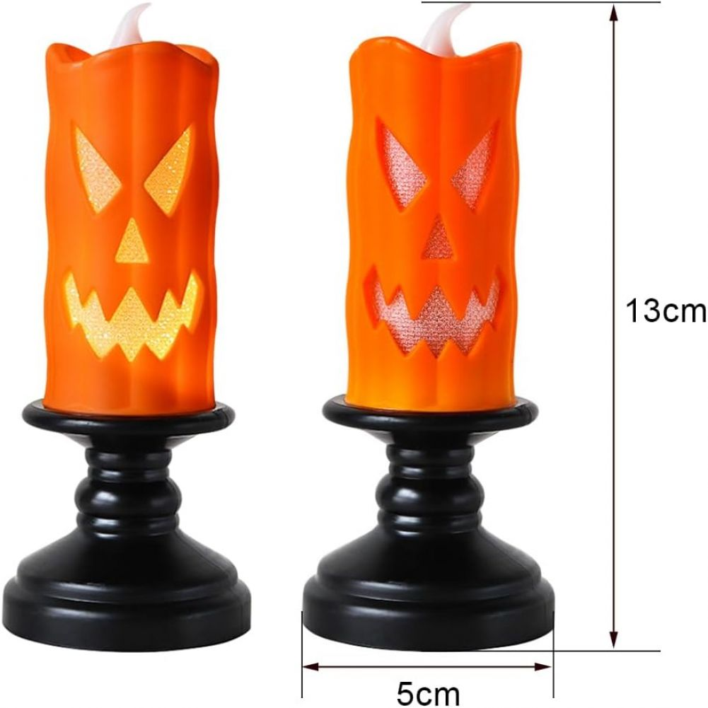 Zwei orangefarbene Halloween-Kerzendekorationen. Jede Kerze hat ein geschnitztes Kürbisgesicht. Sie stehen auf schwarzen Ständern. Abmessungen sind 13 cm x 5 cm.