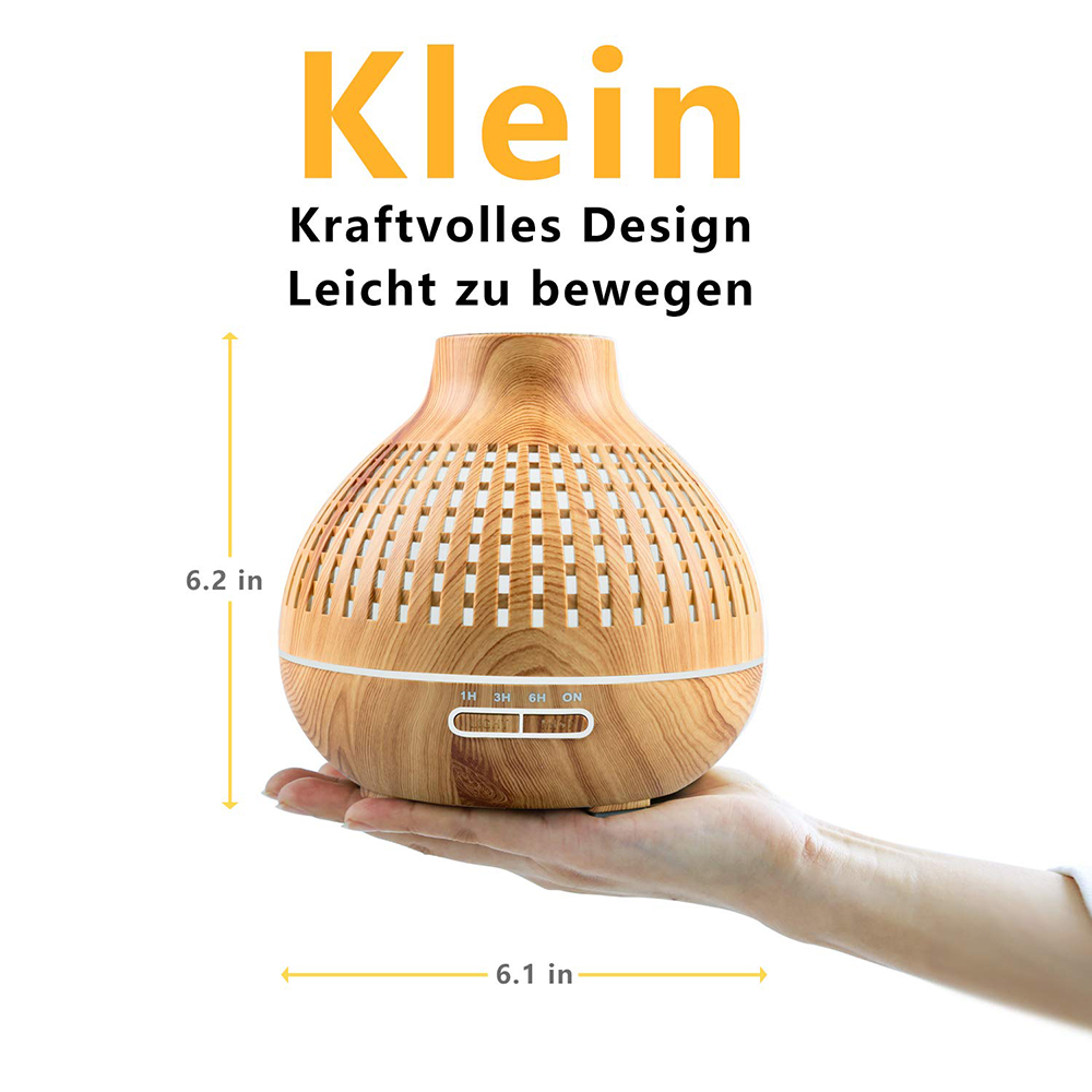 Eine Hand hält einen Aroma-Diffusor aus Holz. Er hat eine runde Form mit einem Gittermuster. Abmessungen werden durch Pfeile angezeigt.