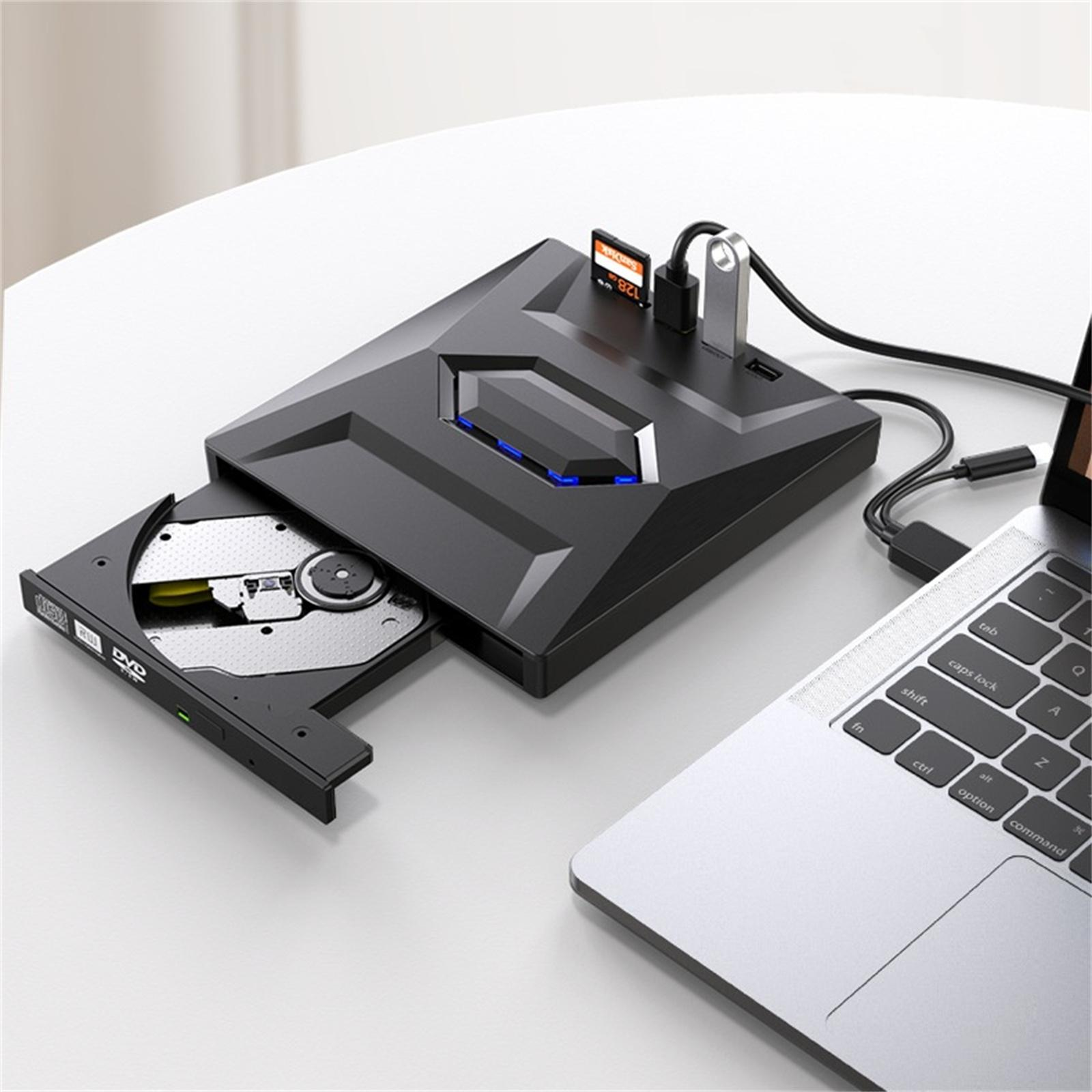 Schwarzes DVD-Laufwerk mit angeschlossenem Laptop. SD-Karte und USB-Laufwerk ebenfalls eingesteckt. Auf einem weißen Tisch platziert.