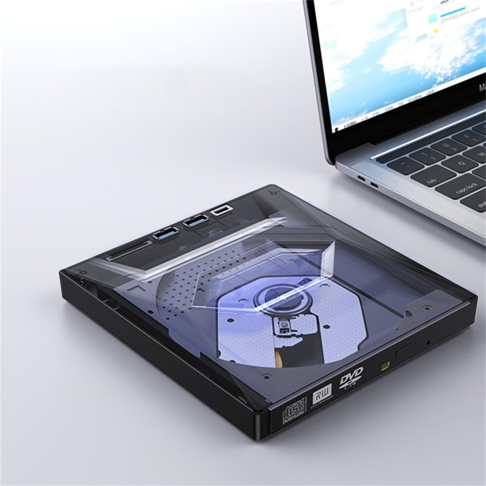 Ein schwarzes externes DVD-Laufwerk neben einem Laptop. Das Laufwerk ist geöffnet und zeigt das Festplattenfach. Der Laptop zeigt einen blauen Himmel.