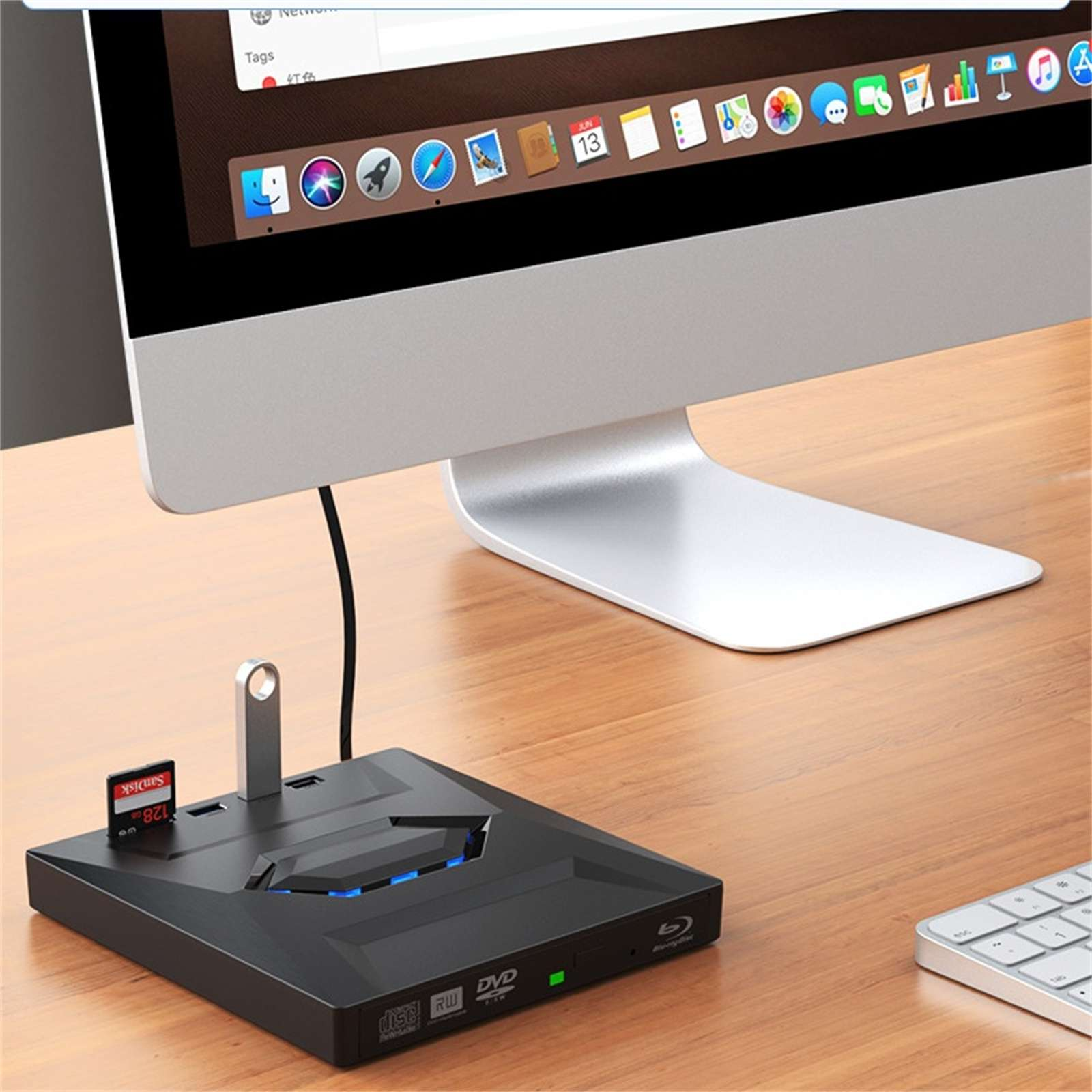Ein Computer-Setup mit Monitor, Kartenleser und Tastatur auf einem Holztisch. Ein USB-Stick und eine SD-Karte sind eingesetzt.