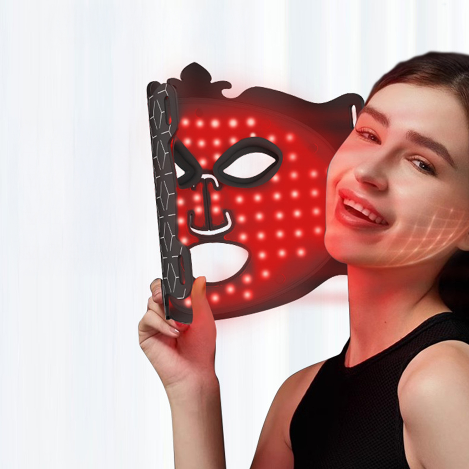 Eine Frau lächelt und hält eine rote LED-Gesichtsmaske. Die Maske hat rote Lichter. Der Hintergrund ist ein weißer Vorhang.