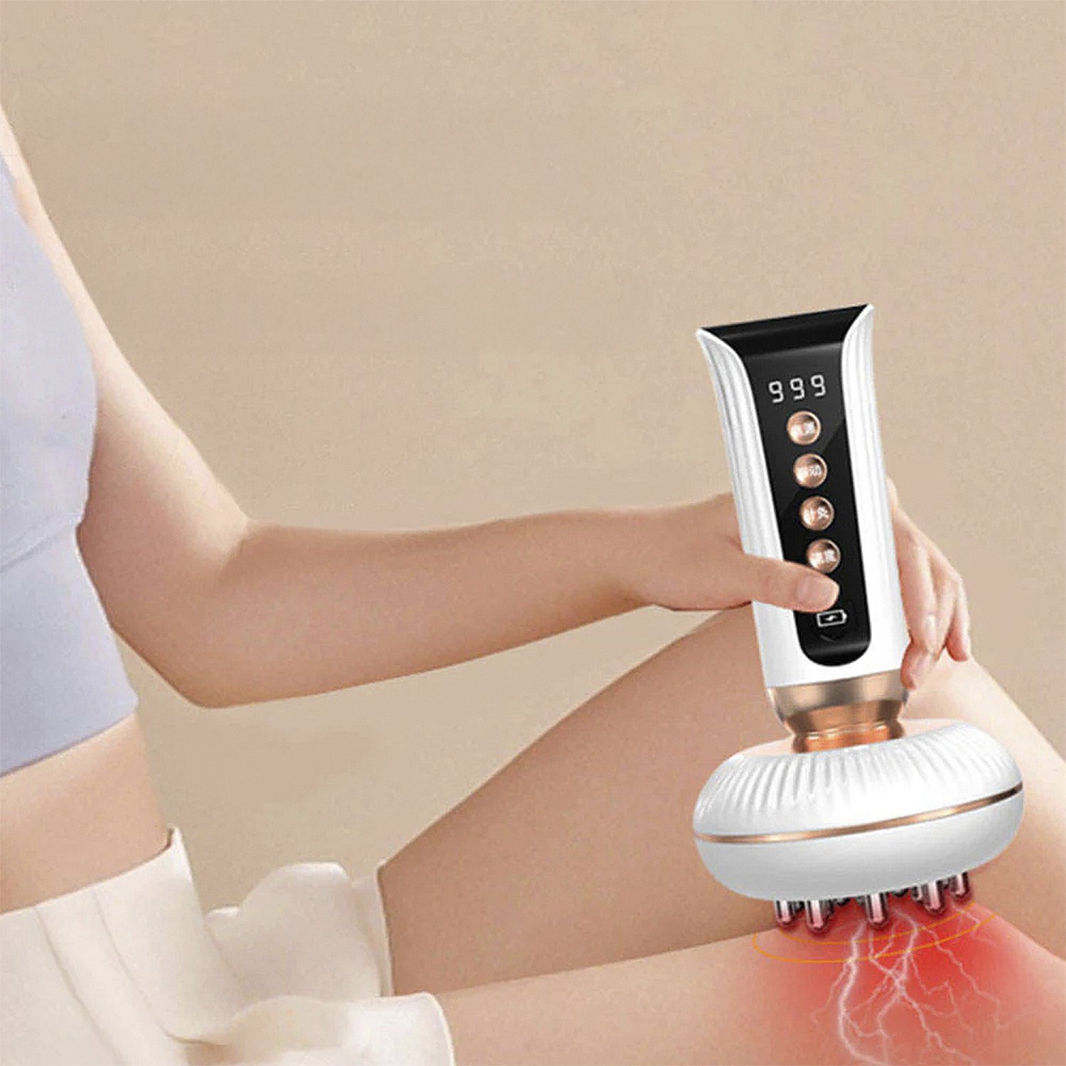 Una persona usa un dispositivo de masaje blanco y dorado en su rodilla. El dispositivo tiene una pantalla digital que muestra '999'.