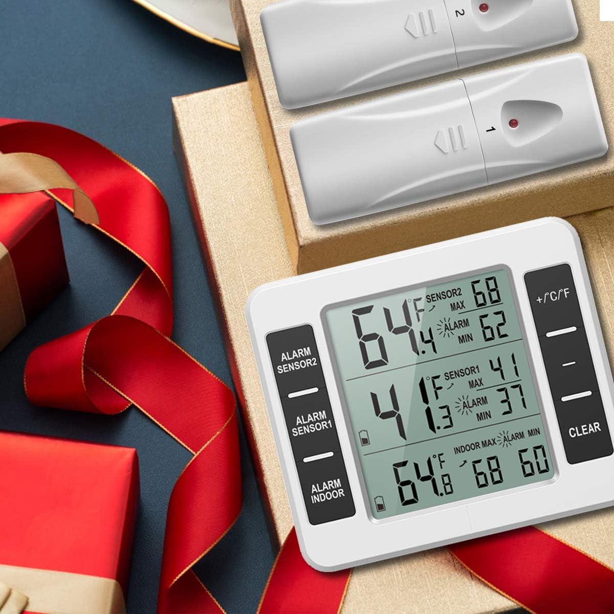 Ein weißes digitales Thermometer zeigt Temperaturwerte an. Zwei weiße Sensoren sind oben. Geschenke und rotes Band im Hintergrund.
