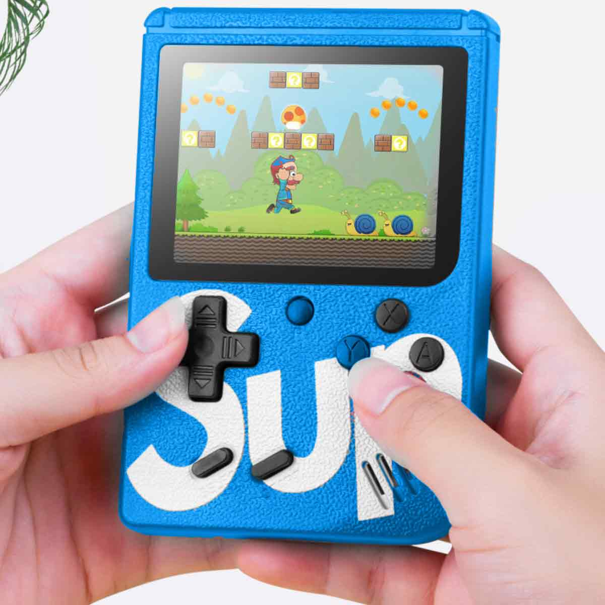 Eine Person hält eine blaue Handheld-Spielkonsole. Der Bildschirm zeigt eine verpixelte Spielszene. Hände bedienen die Knöpfe und das Steuerkreuz.