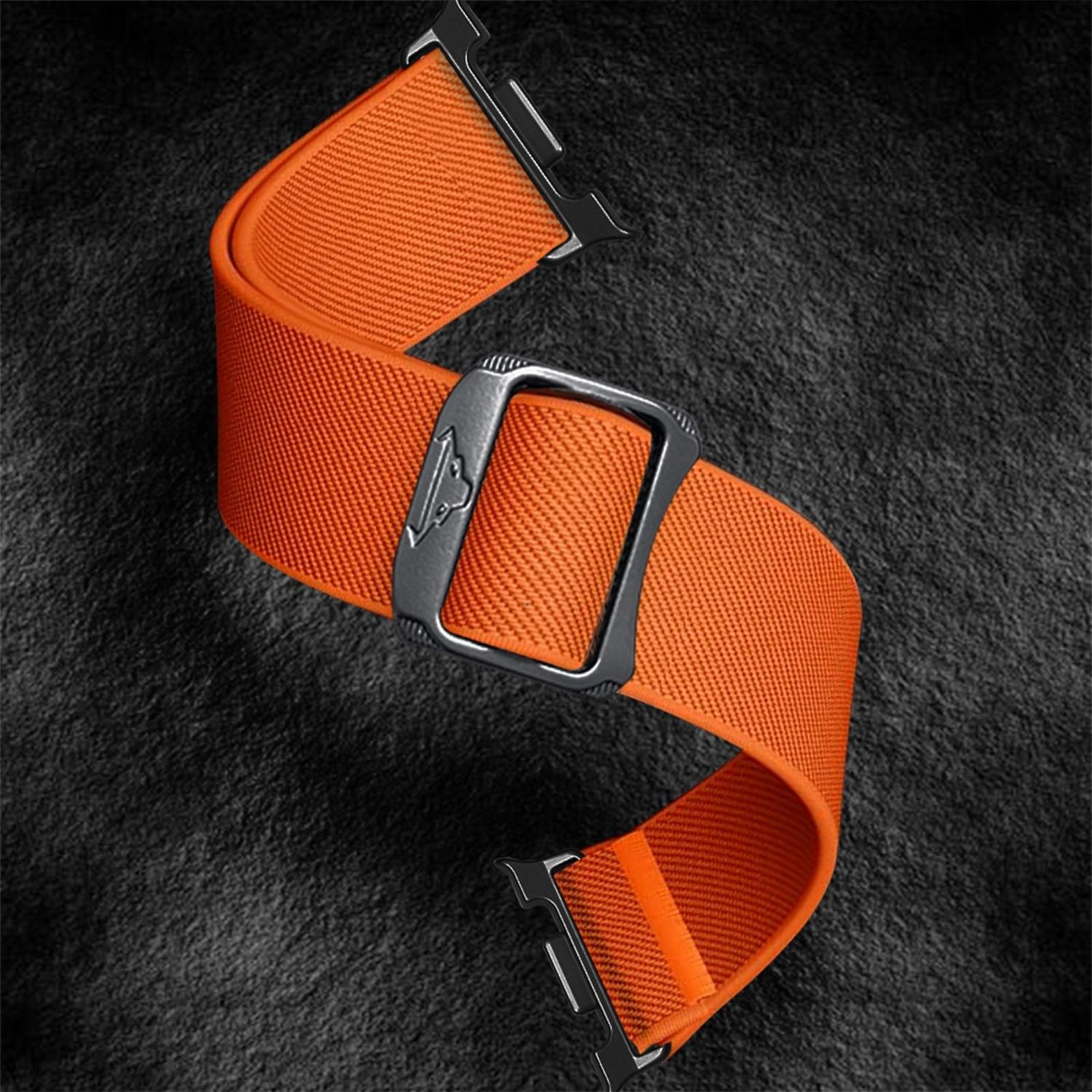 Ein orangefarbenes Uhrenarmband mit einer silbernen Schnalle liegt auf einer dunklen, strukturierten Oberfläche. Das Armband ist gebogen.