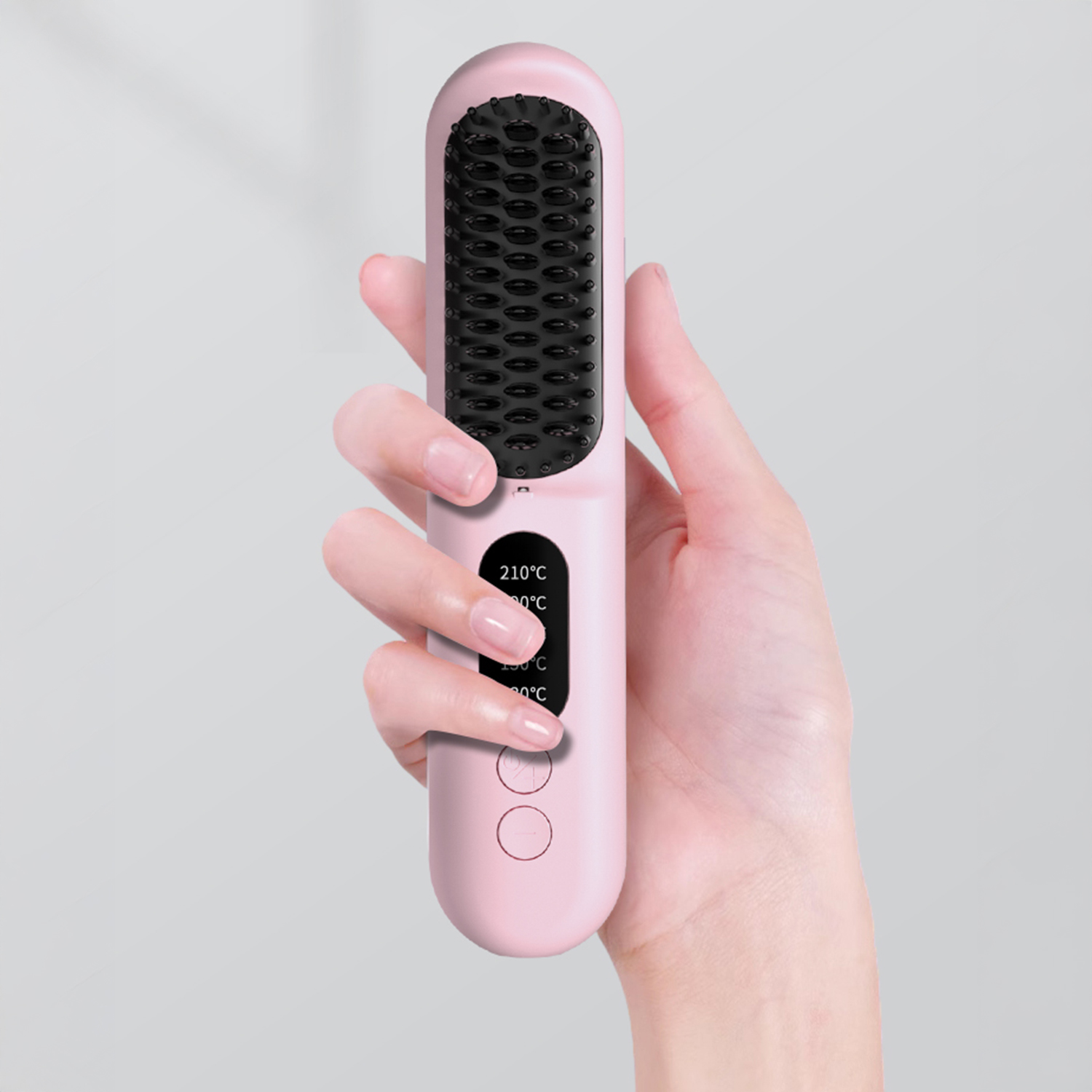 Una mano che tiene una spazzola lisciante rosa. La spazzola ha setole nere e un display digitale.