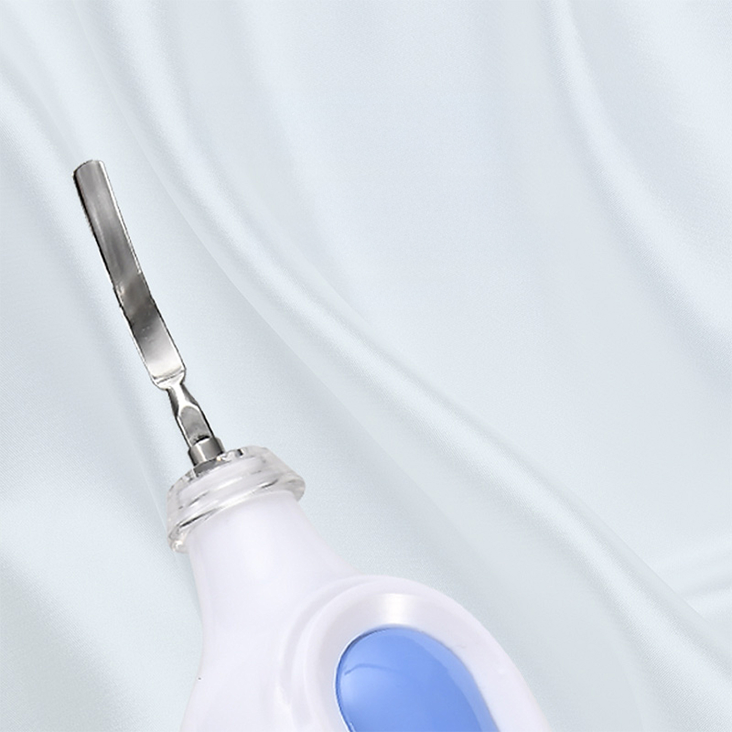 Una herramienta médica blanca y azul con una cuchilla plateada sobre un fondo blanco ondulado.
