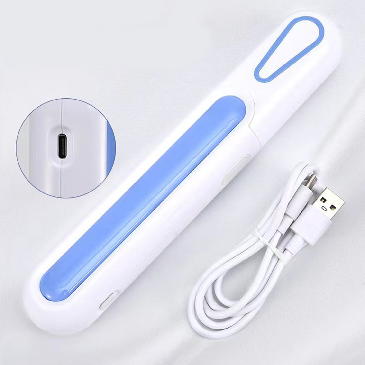 Un dispositivo electrónico blanco y azul con cable de carga USB. Primer plano muestra detalles y puerto del dispositivo. En superficie blanca.