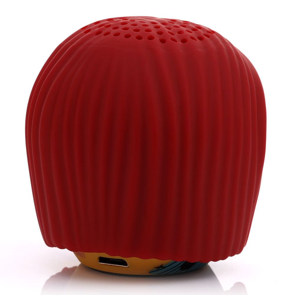 Un altoparlante rosso e arrotondato con texture a coste. La parte superiore ha piccoli fori. La base è gialla e blu. Una porta USB è visibile.