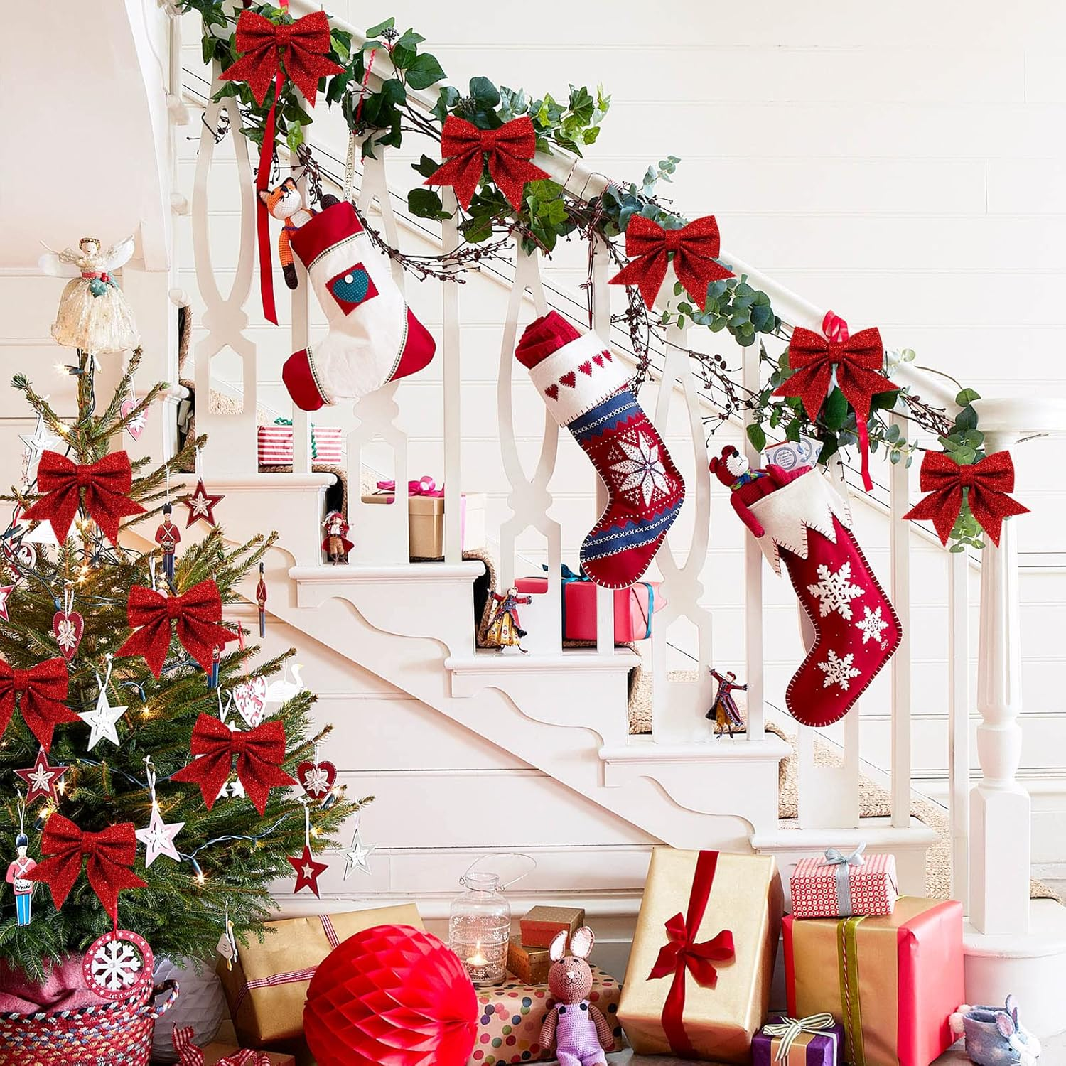 Eine Weihnachtsszene. Ein geschmückter Baum, Strümpfe auf Treppen und verpackte Geschenke sind vorhanden. Rote Schleifen und Ornamente sind sichtbar.