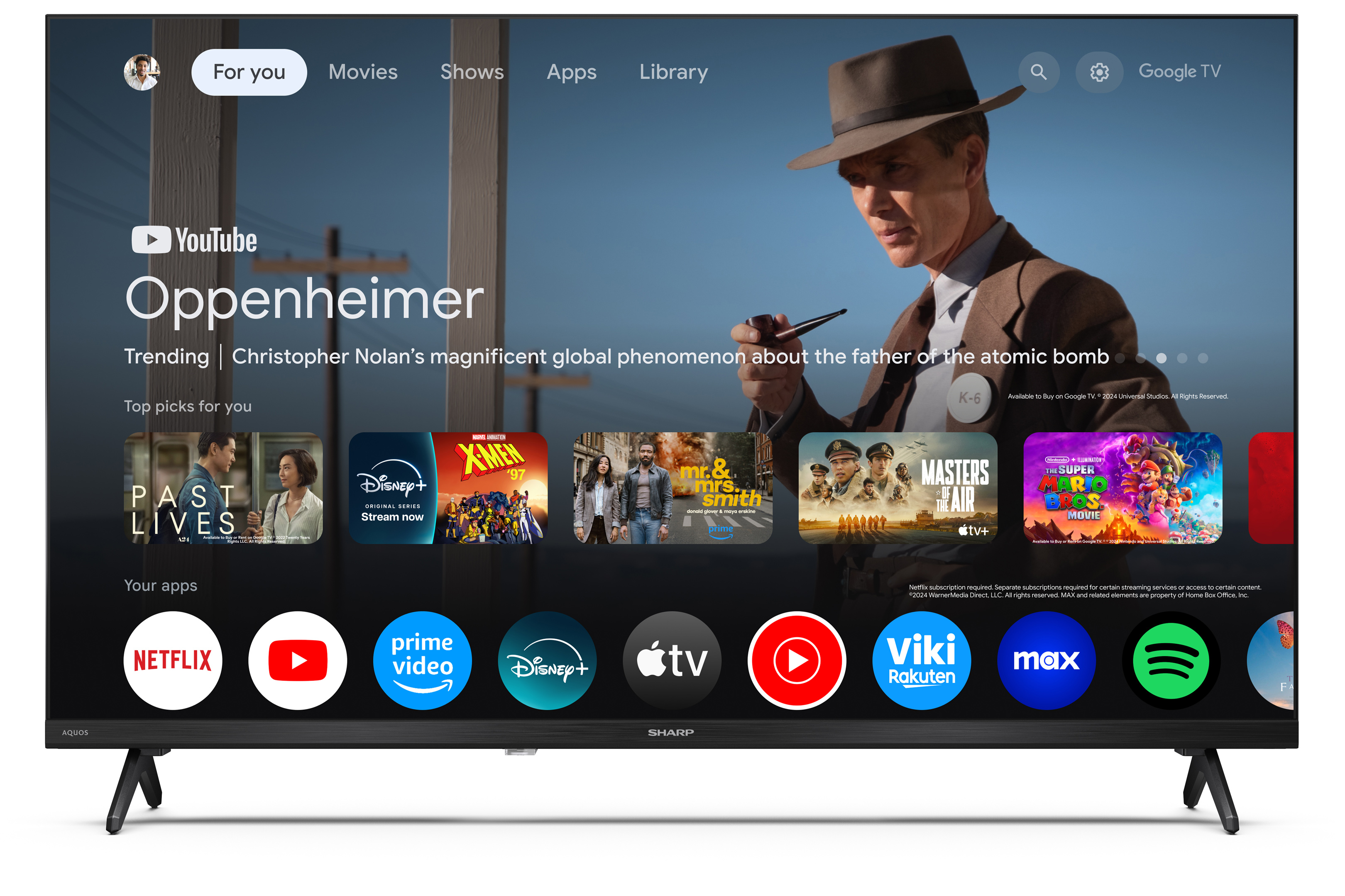 Un écran de télévision affiche le film Oppenheimer. Diverses icônes d'applications sont en bas. Un homme chapeauté est à l'écran.