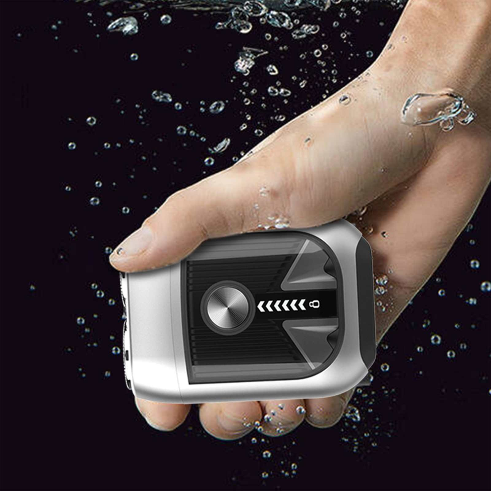 Hand hält ein silbernes und schwarzes Gerät unter Wasser. Blasen umgeben Hand und Gerät vor dunklem Hintergrund.