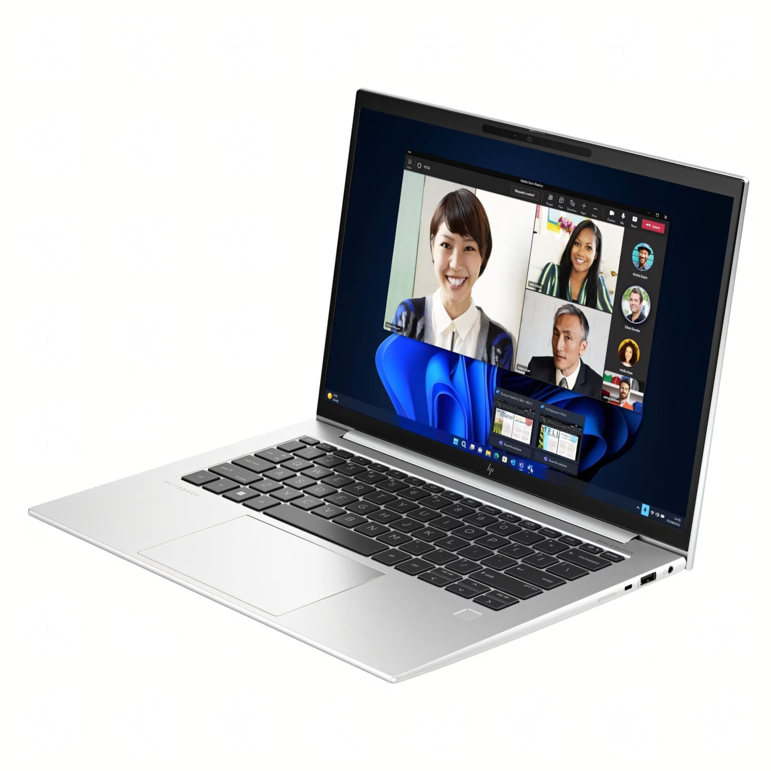 Portátil plateado muestra videollamada con cuatro participantes. La pantalla muestra rostros sonrientes. Teclado y panel táctil visibles.