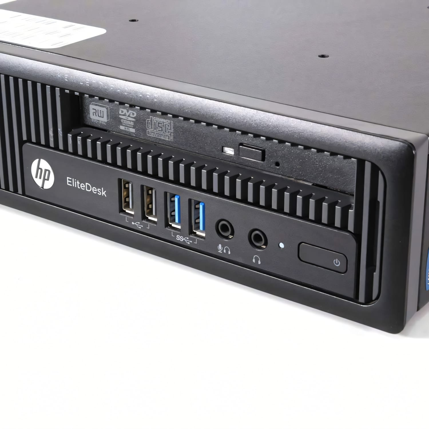 Una computadora HP EliteDesk negra. Tiene una unidad de DVD, puertos USB, conectores de audio y un botón de encendido. El fondo es blanco.