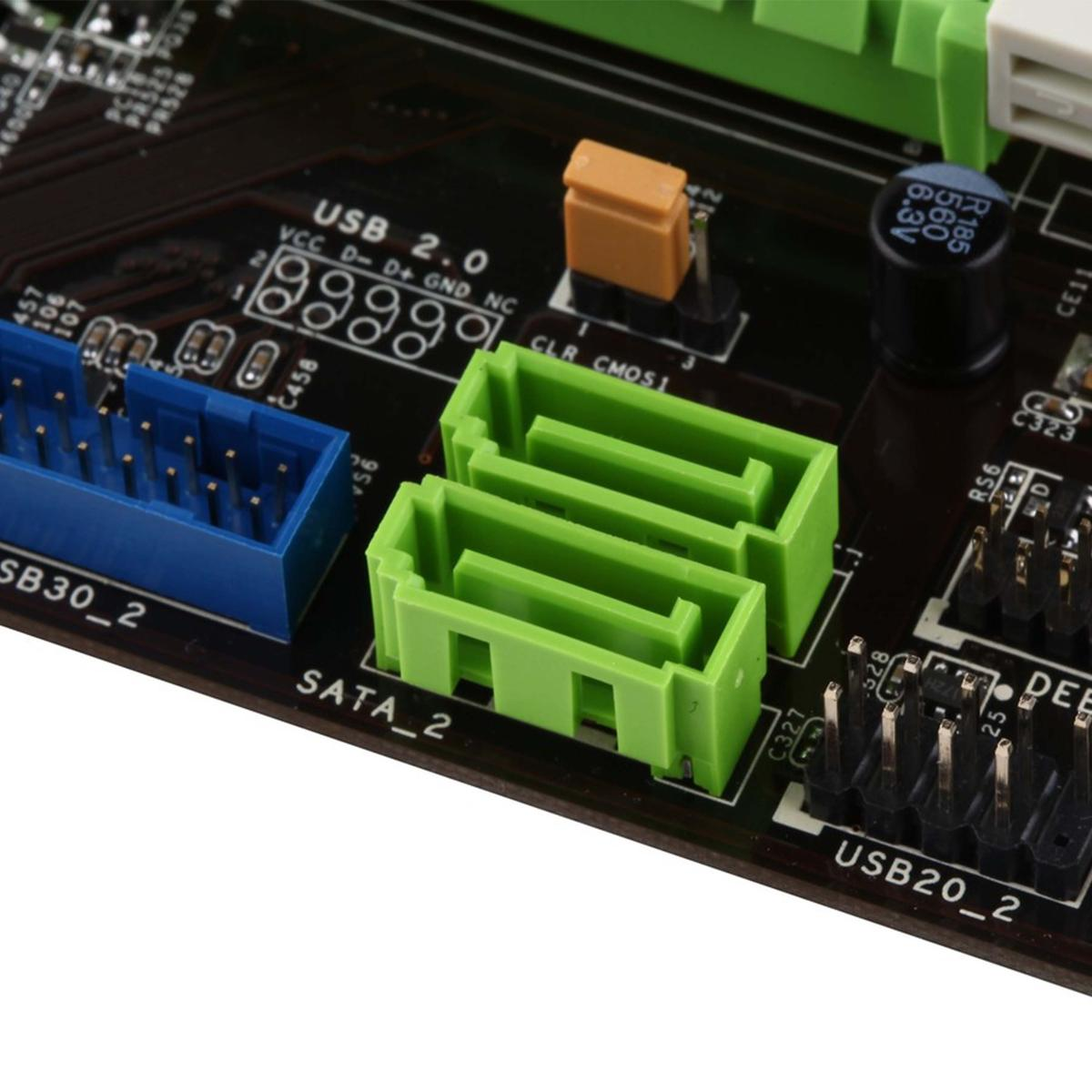 Primo piano di una scheda madre di computer. Connettori verdi e blu, superficie nera e vari componenti elettronici visibili.