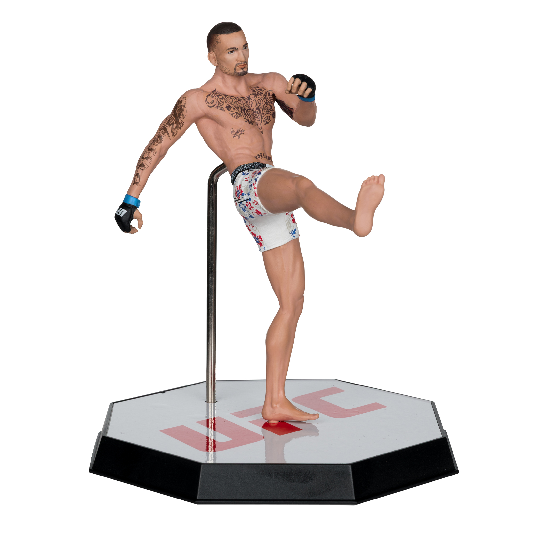 Figur eines Mannes in Kampfpose, mit Tattoos, Shorts und Handschuhen. Er steht auf einer Basis mit UFC-Logo, weißer Hintergrund.