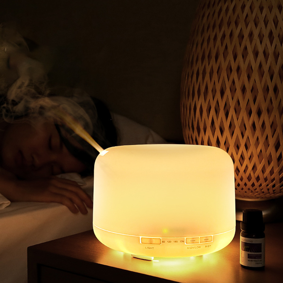 Ein leuchtender Luftbefeuchter stößt Dampf in der Nähe einer schlafenden Person aus. Eine gewebte Lampe und eine Ölflasche stehen auf einem Nachttisch.
