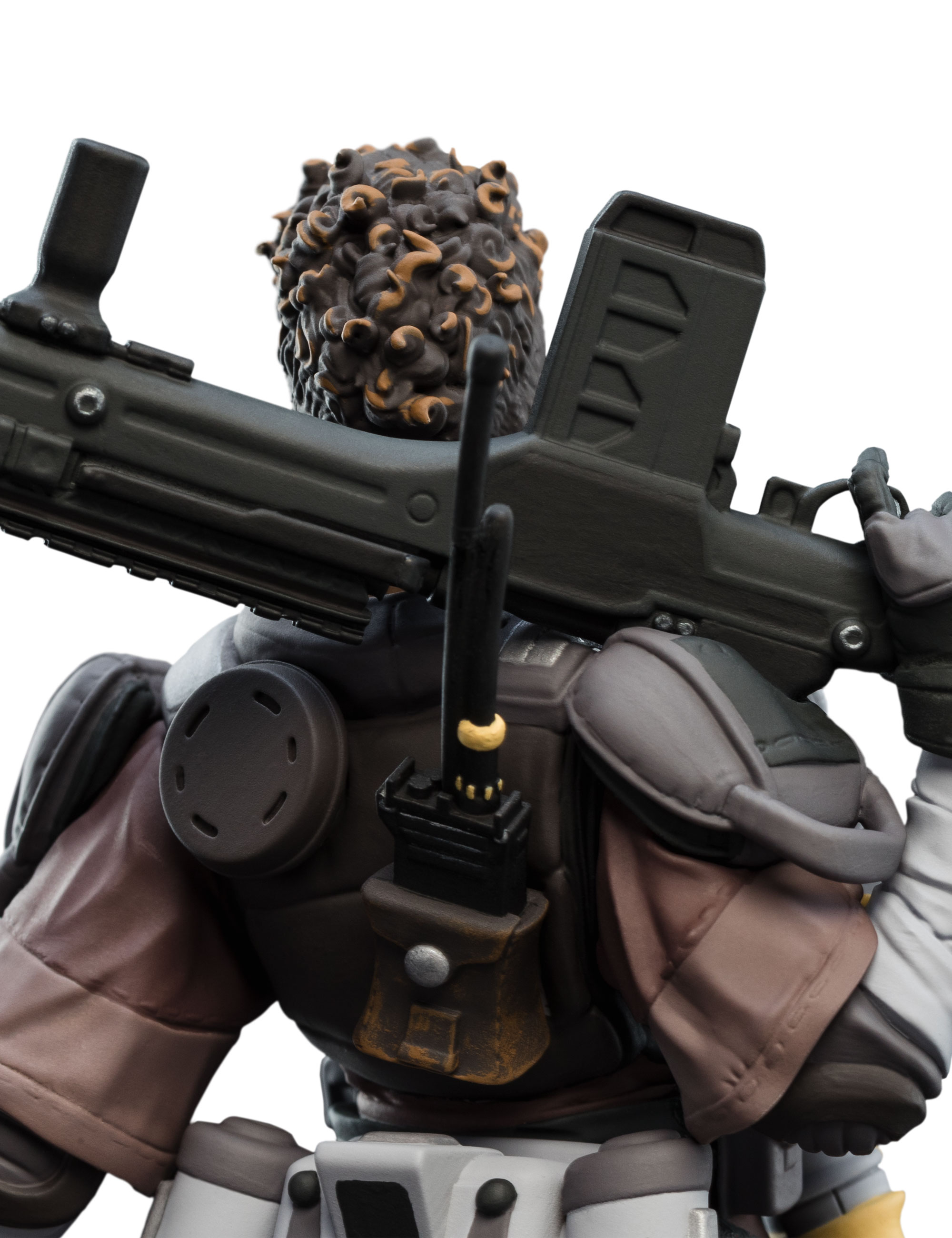 Eine Figur mit lockigem Haar hält ein Gewehr. Die Figur trägt eine taktische Ausrüstung mit Funkgerät und brauner Tasche.