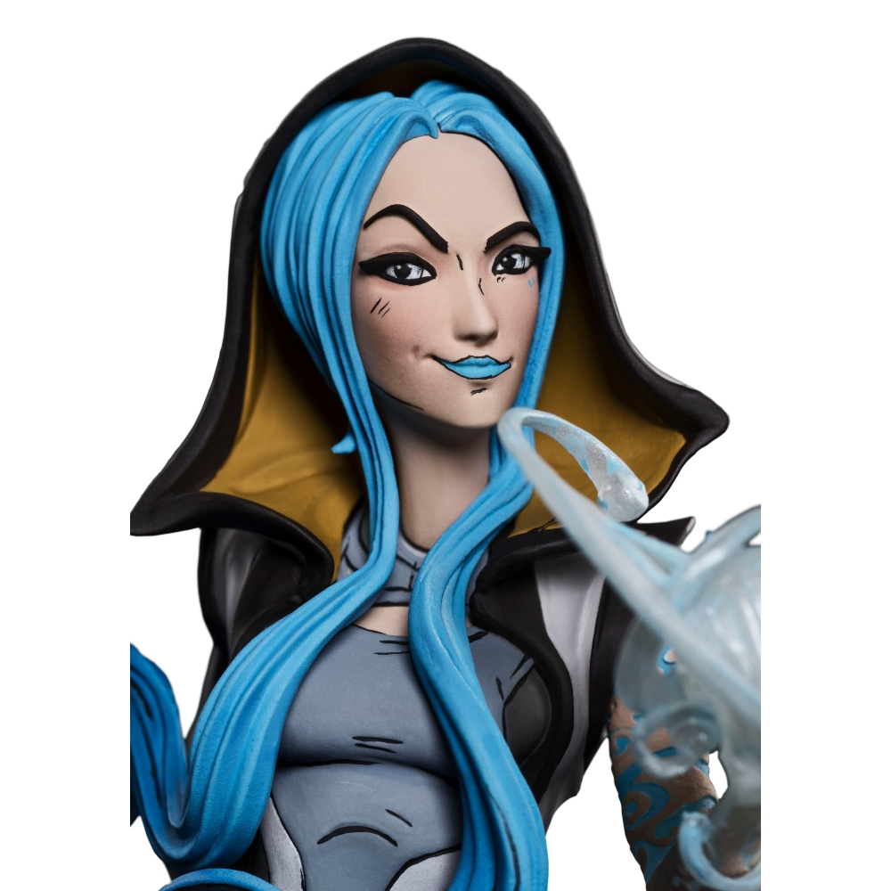 Eine Figur einer Frau mit blauen Haaren und Lippen, die eine Kapuzenjacke trägt. Sie hält einen durchscheinenden blauen Gegenstand.