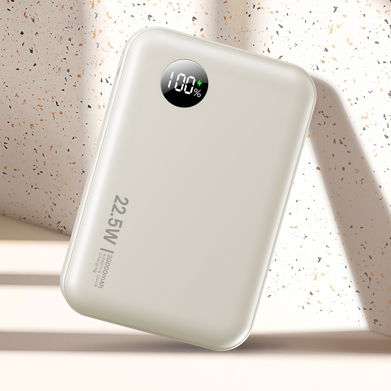 Un power bank beige mostra la carica al 100%. C'è la scritta "22.5W | 20000mAh Adaptive Quick Charging".