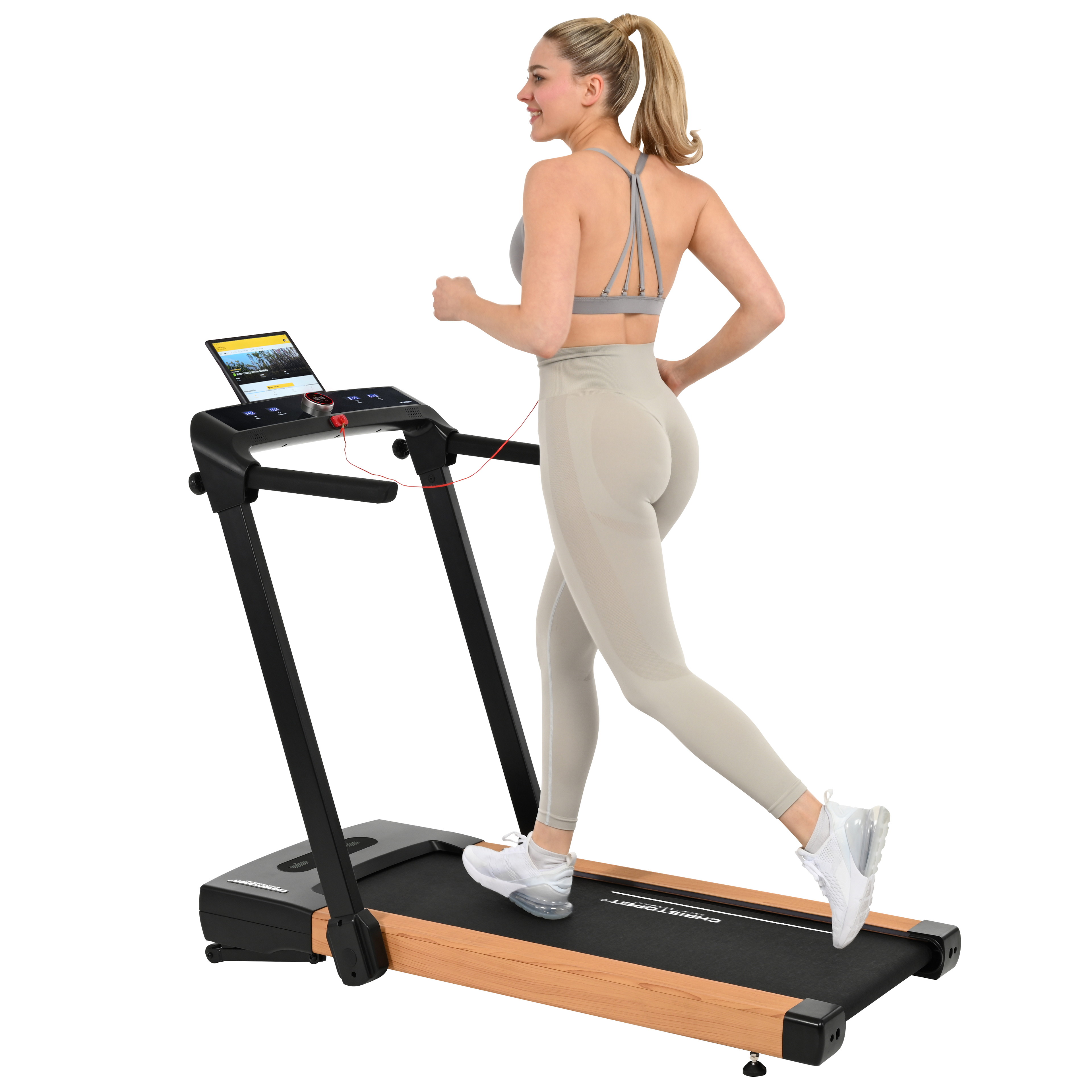 Frau läuft auf dem Laufband. Sie trägt einen grauen Sport-BH und Leggings. Ein Tablet befindet sich auf der Maschine.
