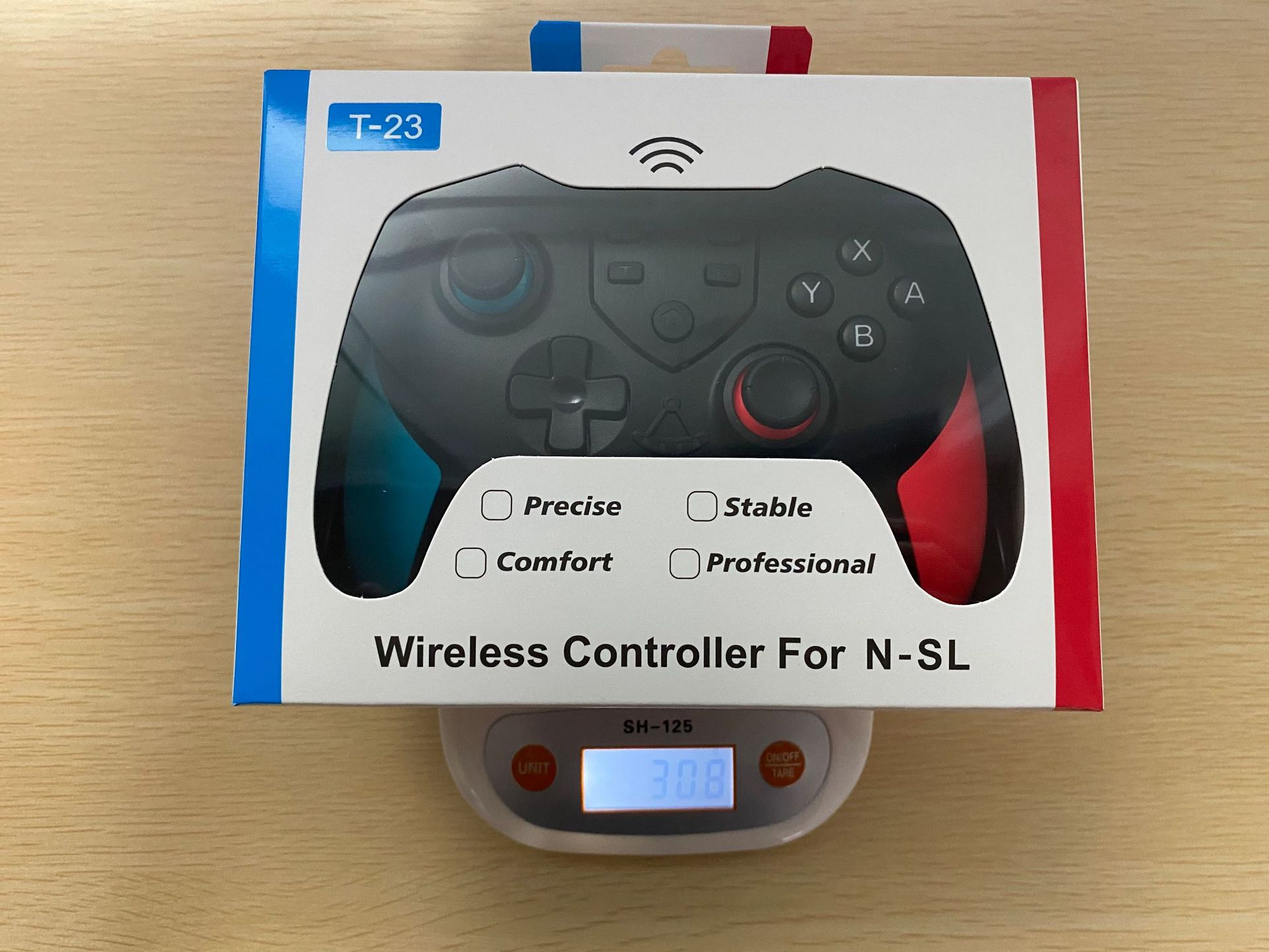 Eine Spielcontroller-Box liegt auf einer Waage. Die Box ist weiß mit blauen und roten Seiten. Sie trägt die Aufschrift 'Wireless Controller For N-SL'.