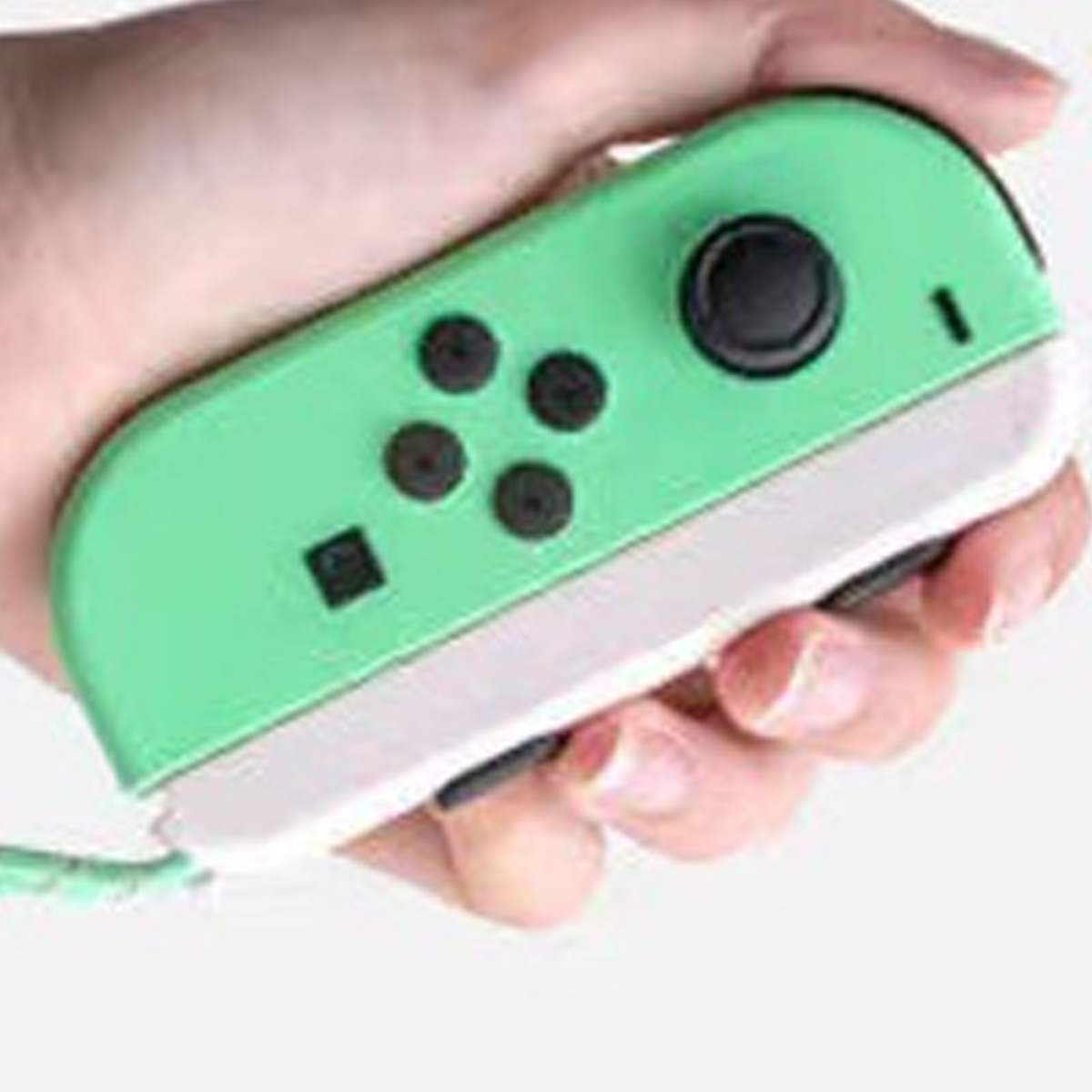 Hand hält einen grün-weißen Nintendo Switch Joy-Con-Controller. Er hat schwarze Knöpfe und einen Joystick.