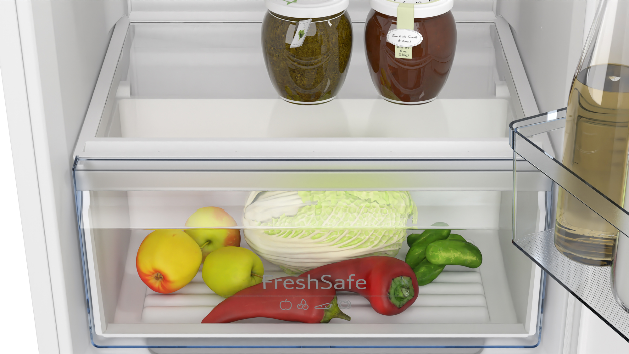 Interno del frigorifero con barattoli, mele, cavolo, peperoni e bottiglie. Il cassetto FreshSafe contiene prodotti. Barattoli sul ripiano superiore.