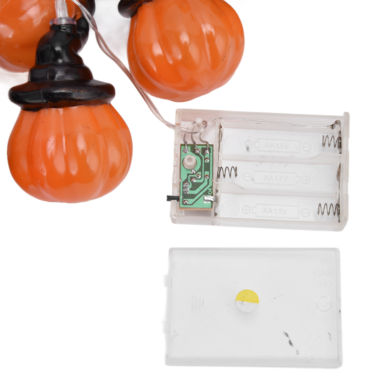 Halloween-Lichterkette mit kürbisförmigen Lichtern und Batteriefach. Weißer Hintergrund. Klare Drähte.