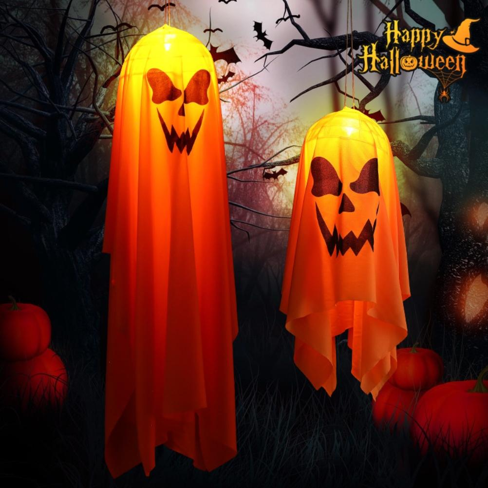 Zwei orangefarbene Halloween-Dekorationen mit geschnitzten Kürbisgesichtern hängen vor einem dunklen Hintergrund mit Fledermäusen und Kürbissen.