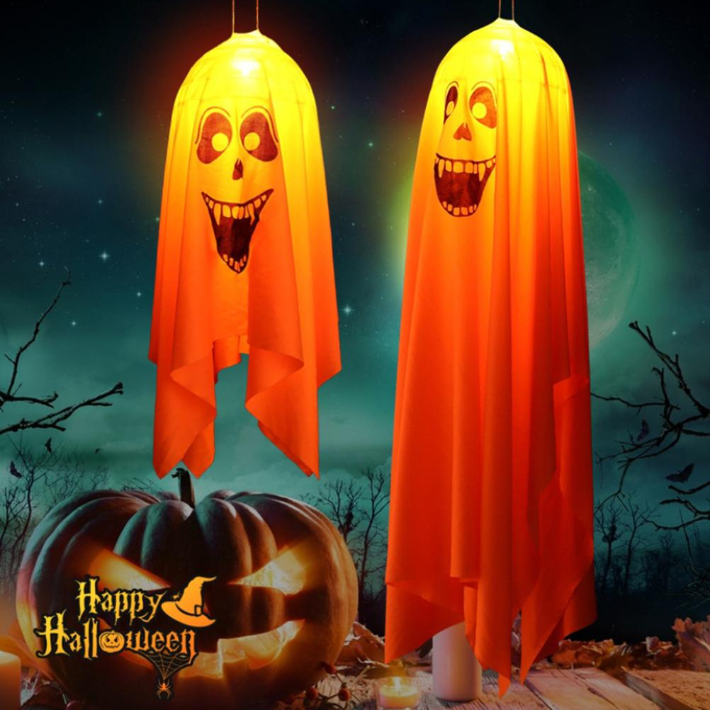 Zwei hängende Geisterdekorationen mit Kürbislaterne und Happy Halloween-Text. Nachtszene mit Sternen und Bäumen im Hintergrund.