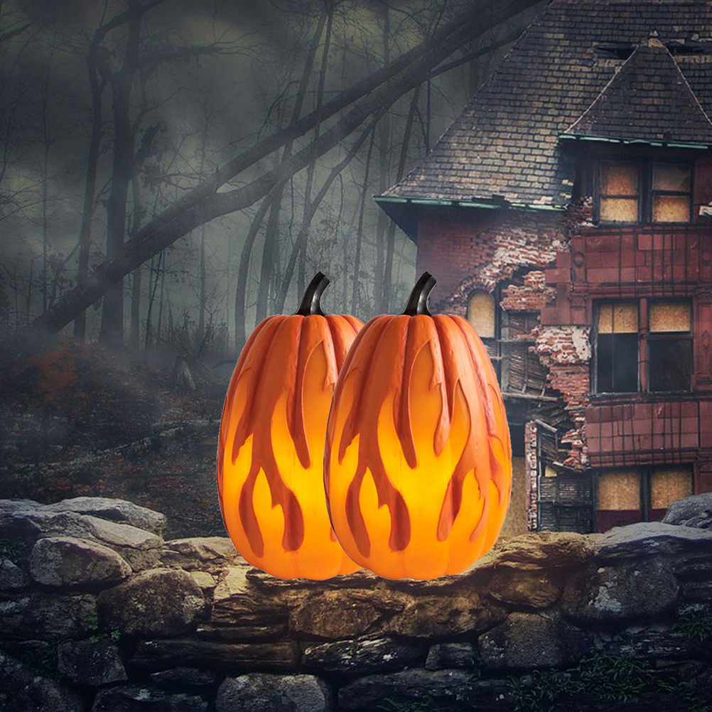 Zwei orangefarbene Kürbisse mit Flammenausschnitten stehen auf einer Steinmauer. Ein unheimliches Haus und ein dunkler Wald sind im Hintergrund.