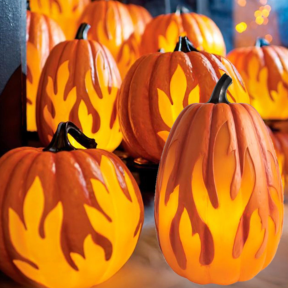 Mehrere orangefarbene Kürbisse mit flammenartigen Ausschnitten sind beleuchtet und deuten auf Halloween-Dekorationen hin. Schwarze Stiele heben sich vom Orange ab.