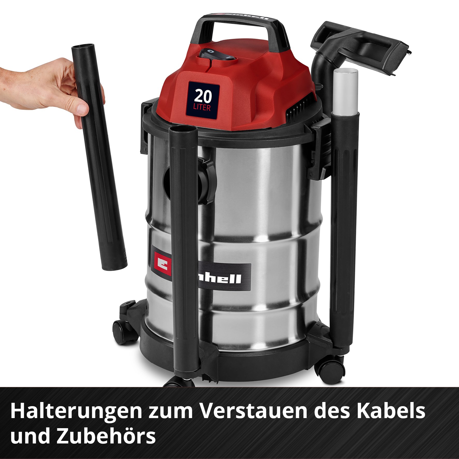 Une main tenant un tube noir, un aspirateur avec un dessus rouge, un conteneur argenté et des accessoires noirs, sur fond blanc.