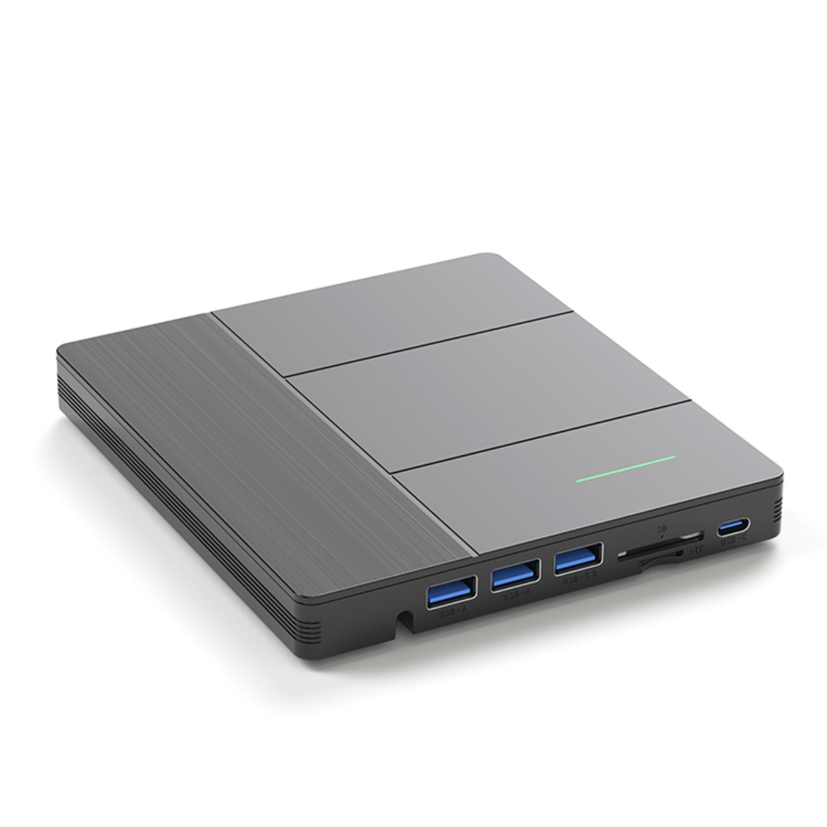Ein graues, rechteckiges Gerät mit strukturierter Oberseite und mehreren USB-Anschlüssen. Ein grünes Licht ist vorne sichtbar. Es liegt auf einer weißen Oberfläche.