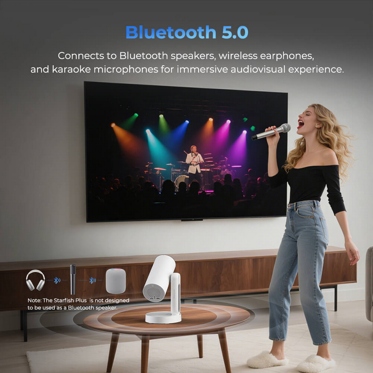Frau singt mit Mikrofon. Großer Fernseher zeigt Konzert. Bluetooth-Lautsprecher und Kopfhörer auf Tisch.