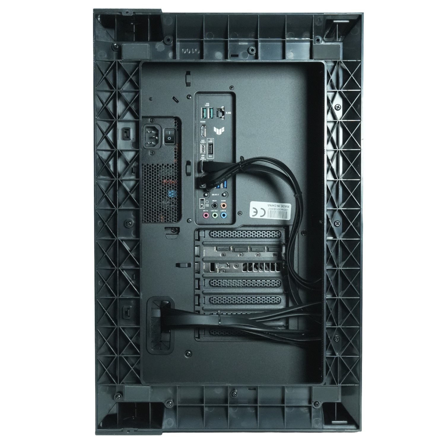 Vista trasera de una caja de ordenador negra. Tiene varios puertos, una fuente de alimentación y una malla para refrigeración. Cables bien organizados.