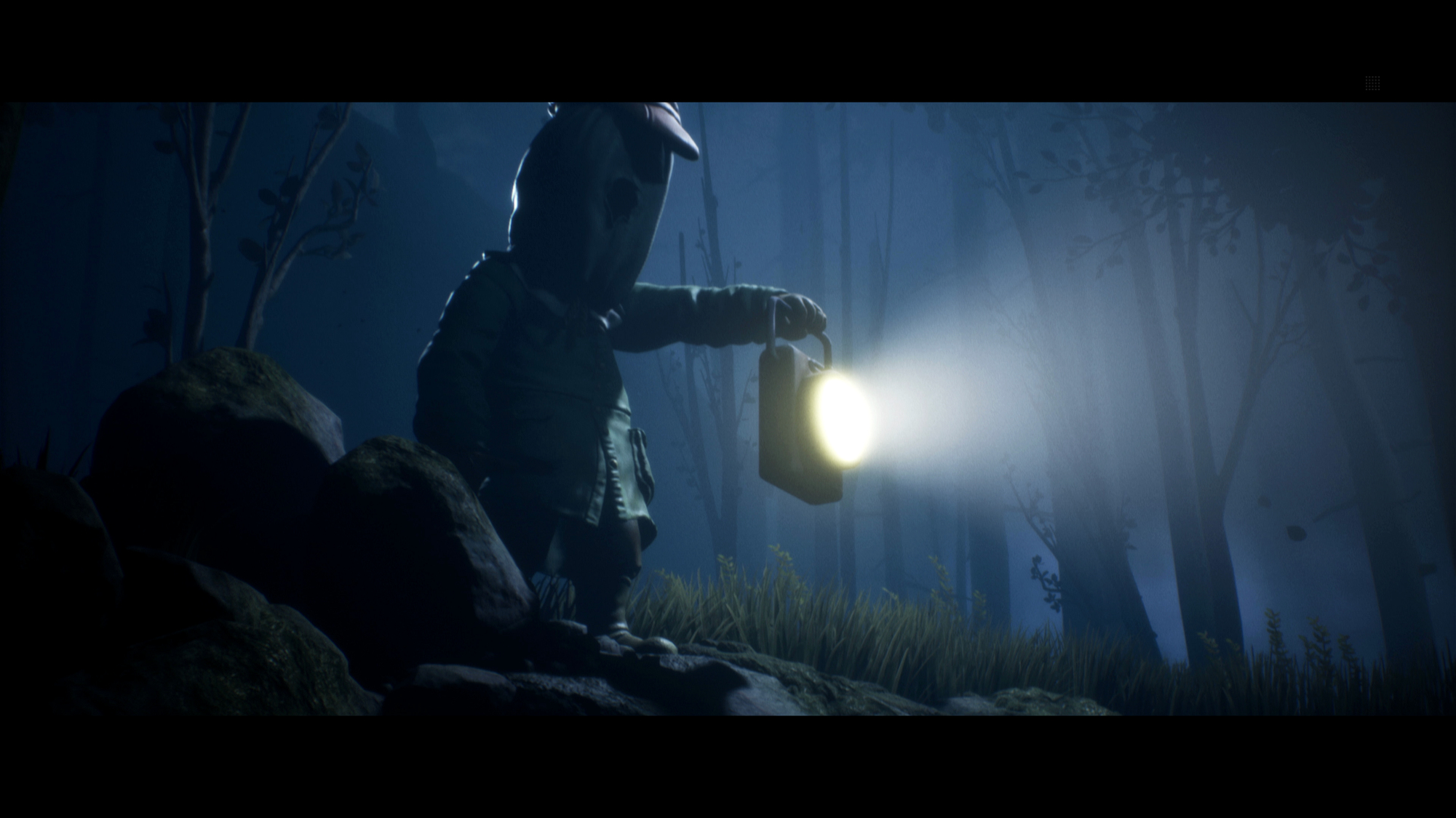 Eine Figur mit Maske und Hut hält eine Laterne in einem dunklen Wald. Licht strahlt von der Laterne aus. Bäume und Felsen umgeben sie.