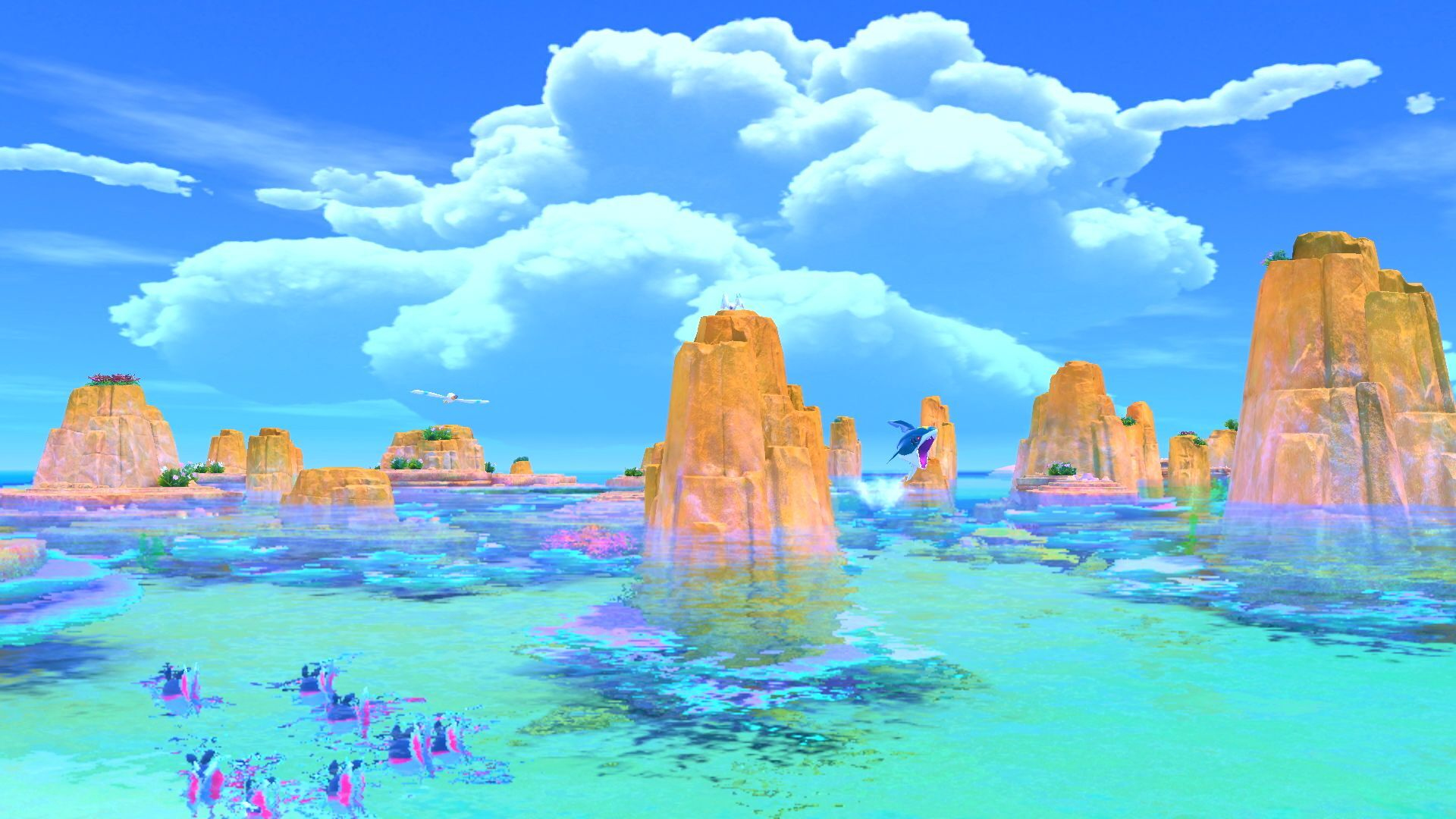 Żywy krajobraz z formacjami skalnymi w wodzie. Niebieskie stworzenie skacze. Białe chmury i niebo dominują w tle.