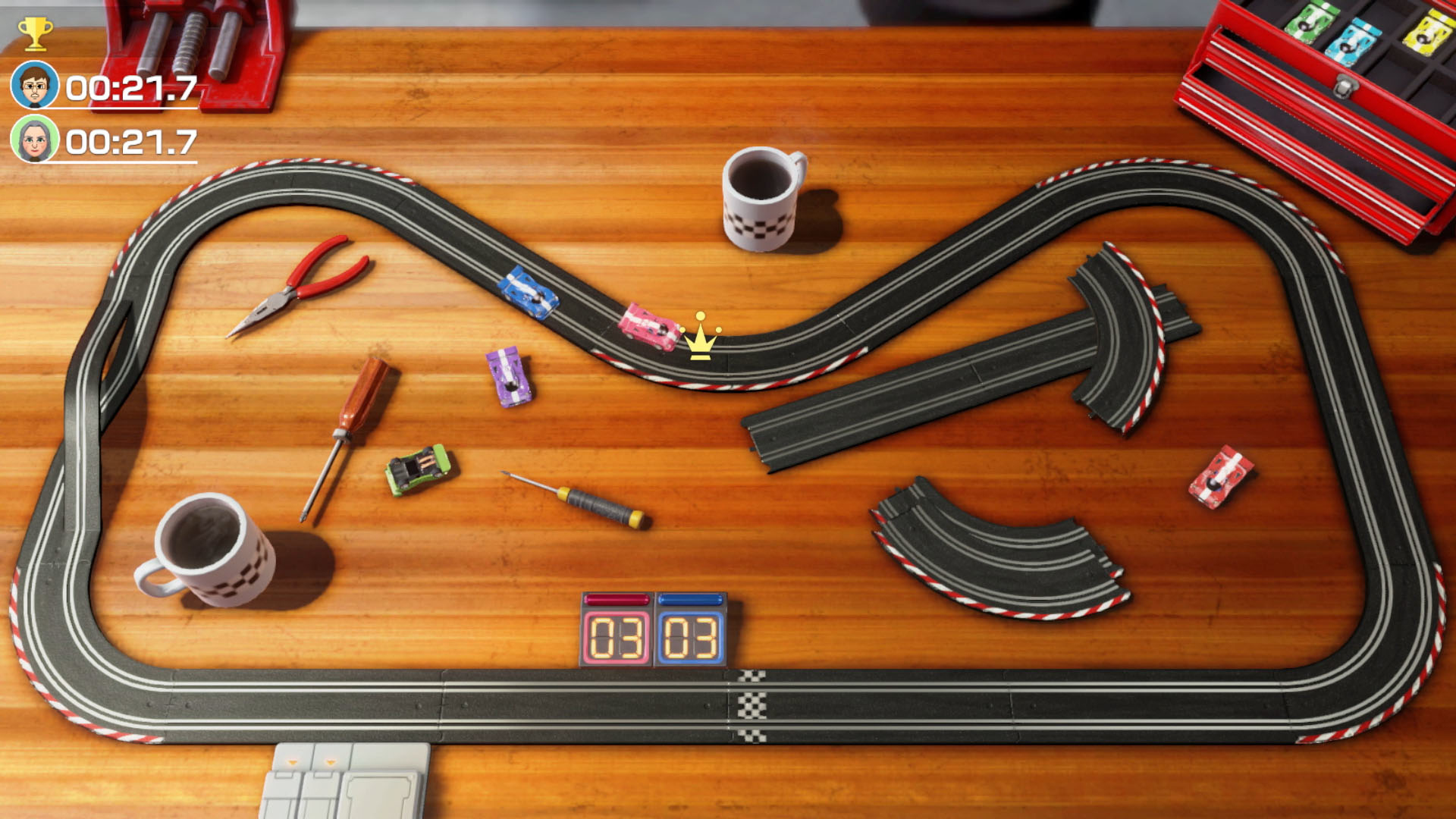 Tor wyścigowy na drewnie z samochodami, narzędziami i timerem. Korona unosi się nad różowym samochodem.