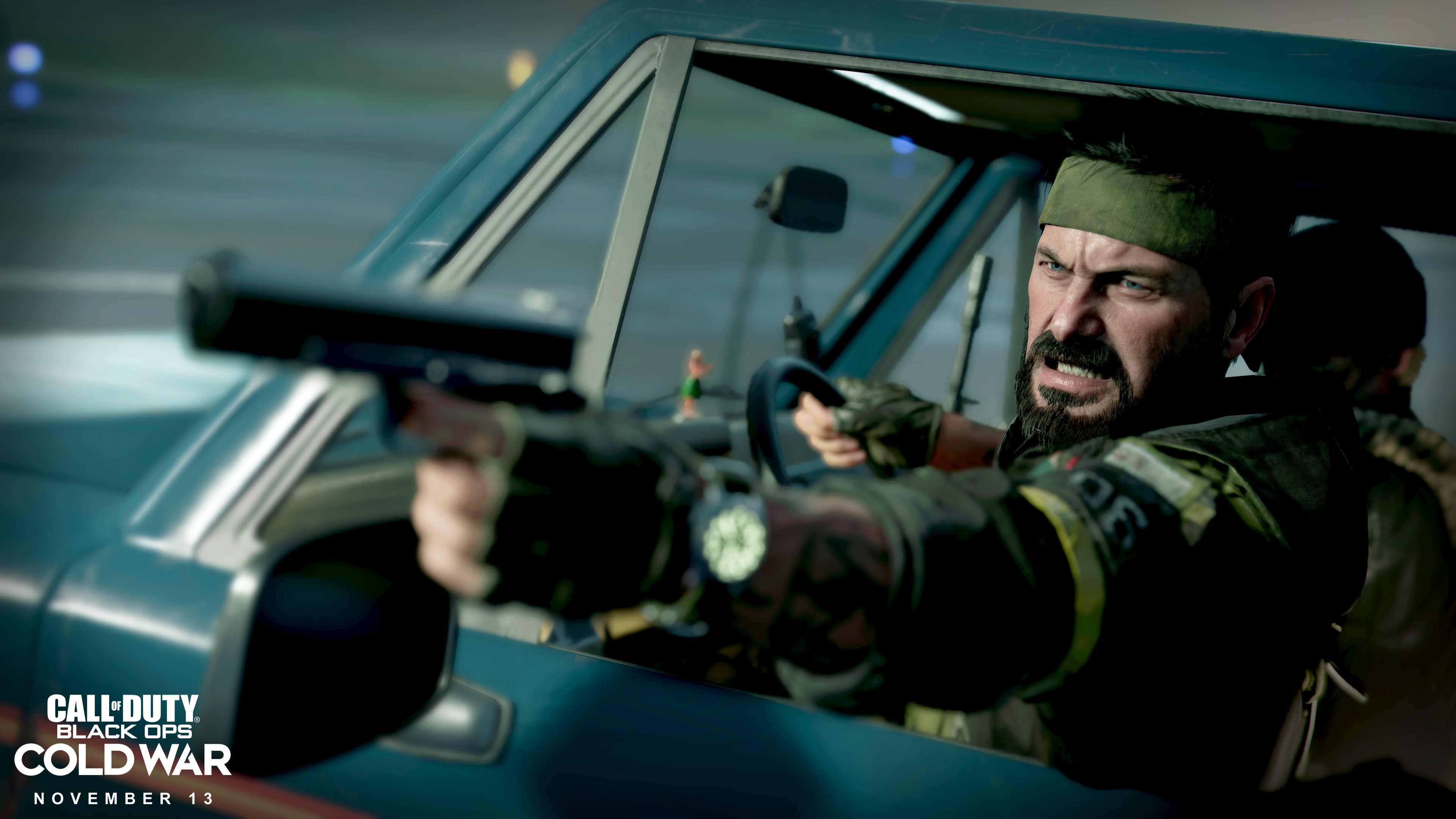 Uomo con fascia verde punta una pistola da un'auto blu. Il logo del gioco 'Call of Duty: Black Ops Cold War' è in basso a sinistra.