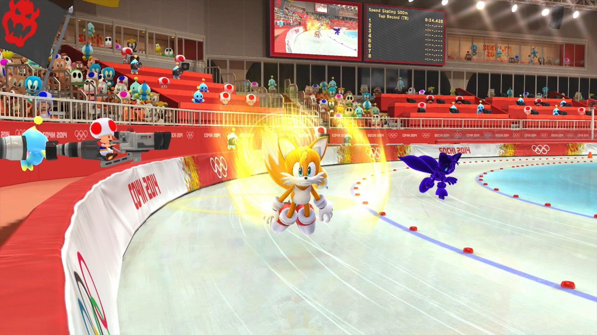 Tails pattina in uno stadio. Anche un personaggio viola sta pattinando. Ci sono molti personaggi tra il pubblico. Striscione di Sochi 2014.