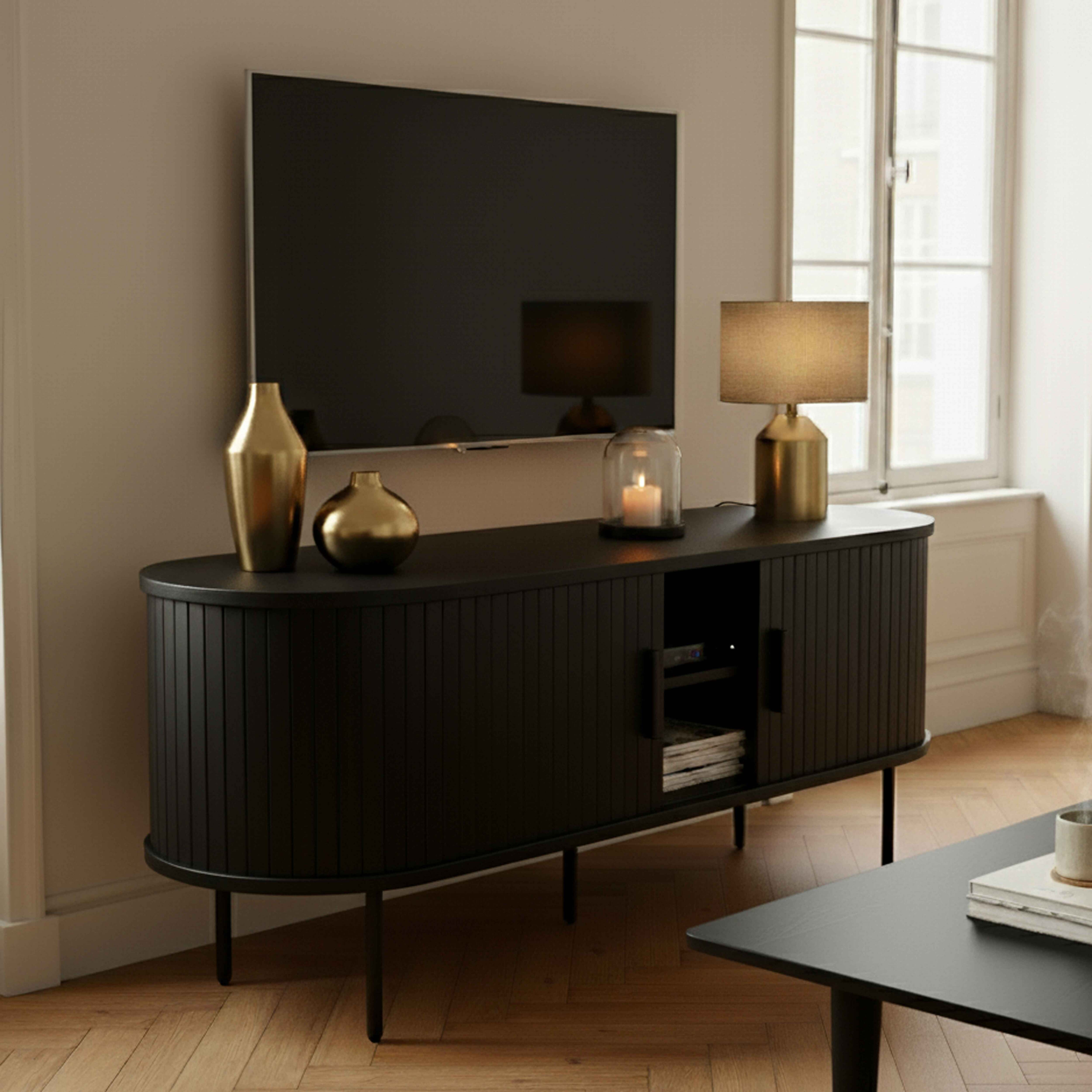 Ein modernes Wohnzimmer mit schwarzem Fernseher, Schrank, Lampe und Vasen. Im Hintergrund ist ein Fenster. Ein Tisch ist im Vordergrund.