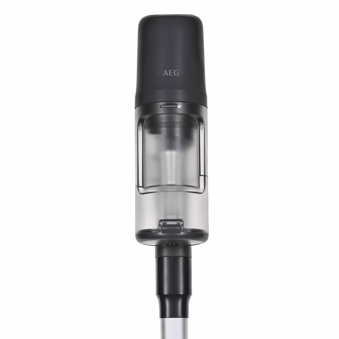 Odkurzacz ręczny. Ma ciemnoszarą górę z napisem 'AEG' i przezroczysty pojemnik na kurz. Uchwyt jest szary z czarną dyszą.