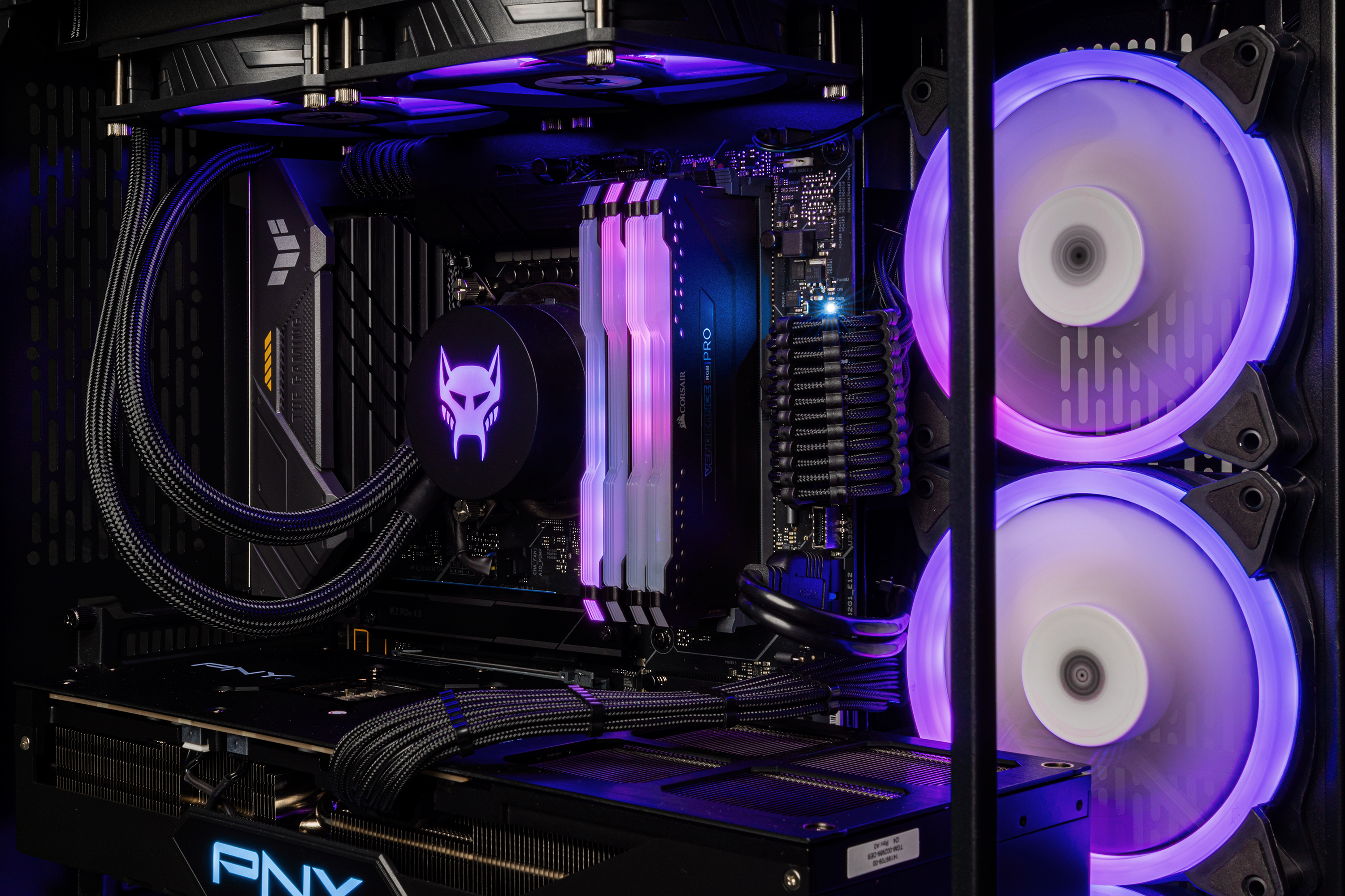 Im Computergehäuse sind Komponenten lila beleuchtet. Lüfter, Kühler, RAM und GPU sind sichtbar.