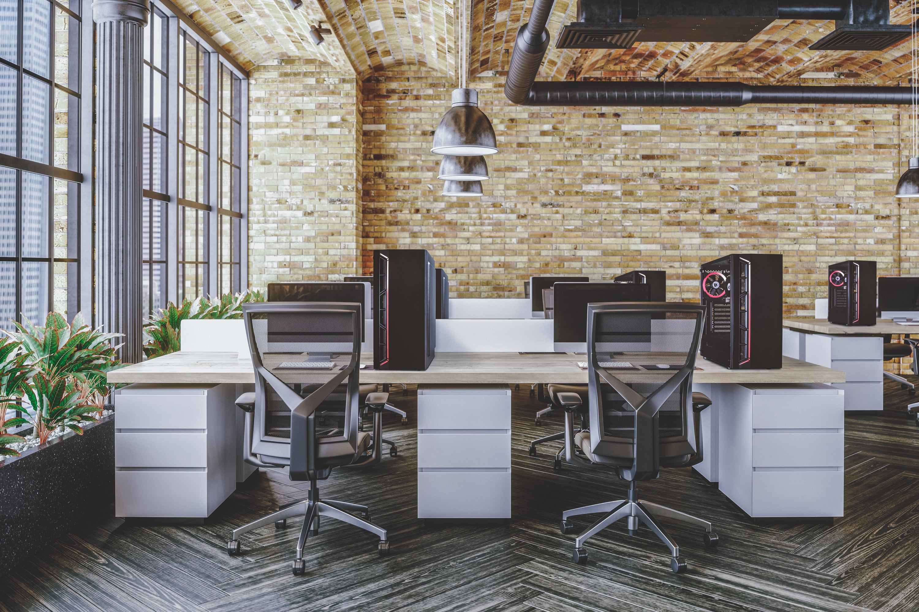 Biuro z biurkami, komputerami i krzesłami. Tło z ceglanej ściany. Obecne są również rośliny i duże okna.