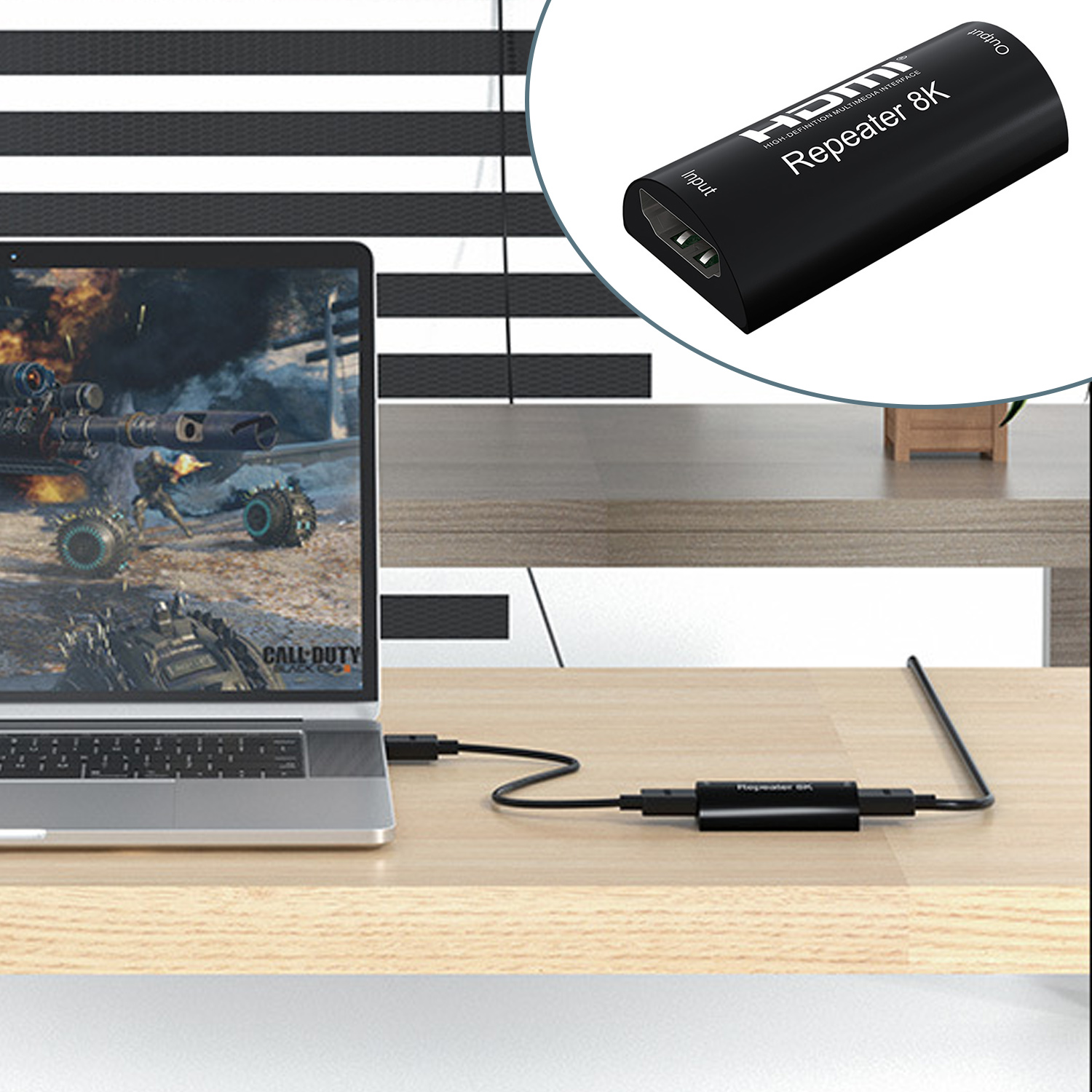 Laptop, der ein Spiel anzeigt, verbunden mit einem schwarzen HDMI-Repeater und eine Nahaufnahme des Repeaters selbst.