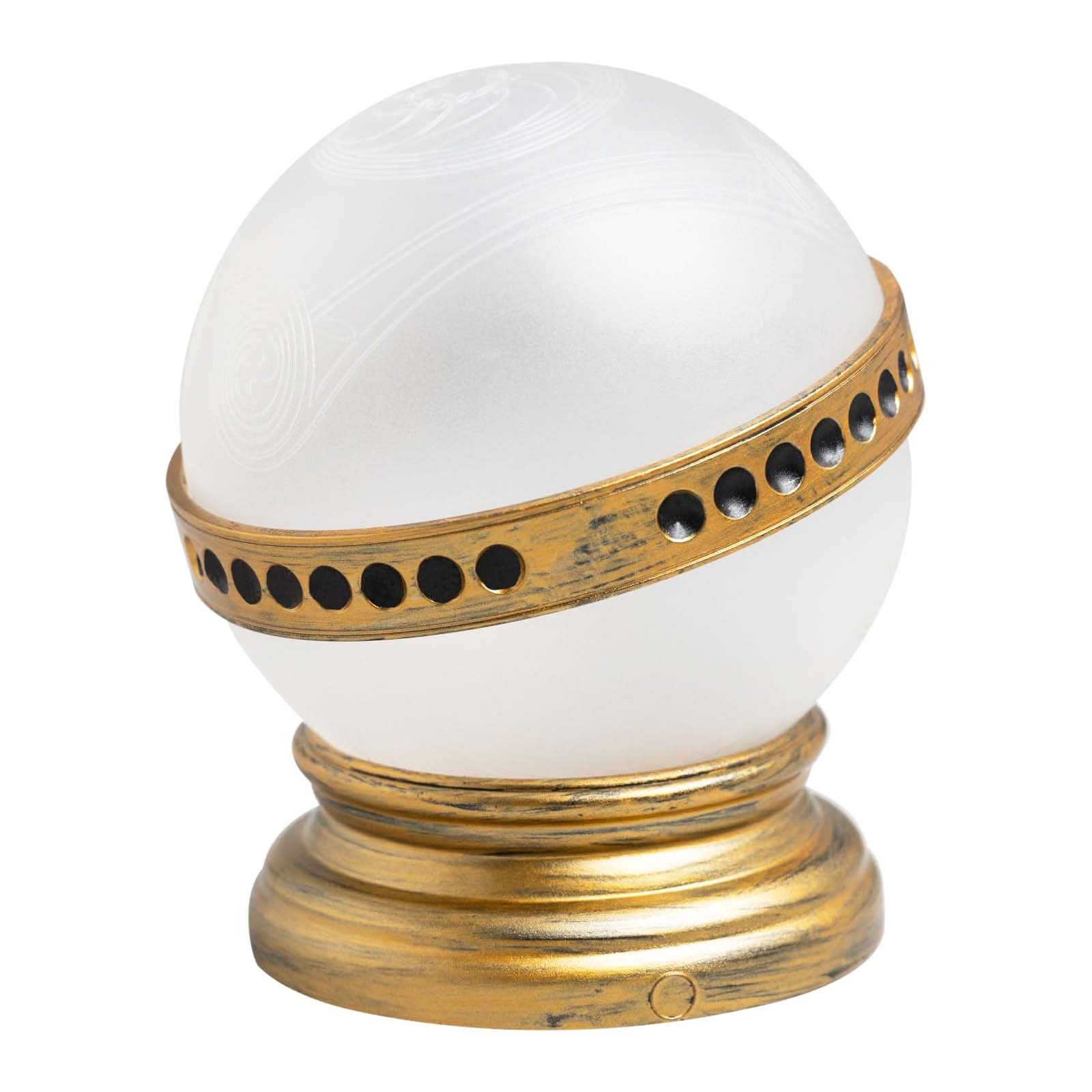 Una sfera decorativa, bianca con linee incise, in una fascia color oro con fori neri, su una base abbinata.