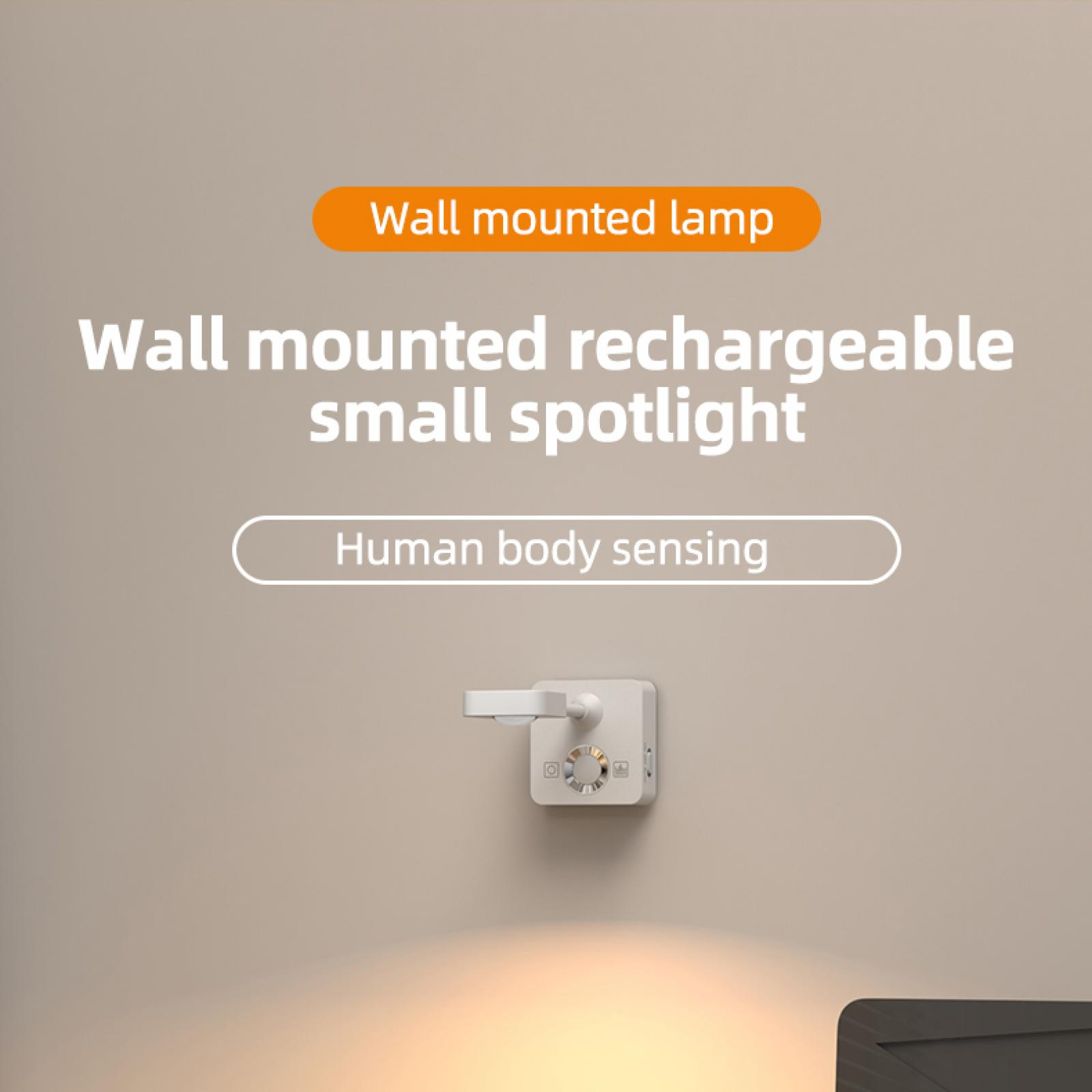 Ein weißer, an der Wand montierter Strahler mit dem Text 'Wall mounted rechargeable small spotlight' an einer hellbraunen Wand.